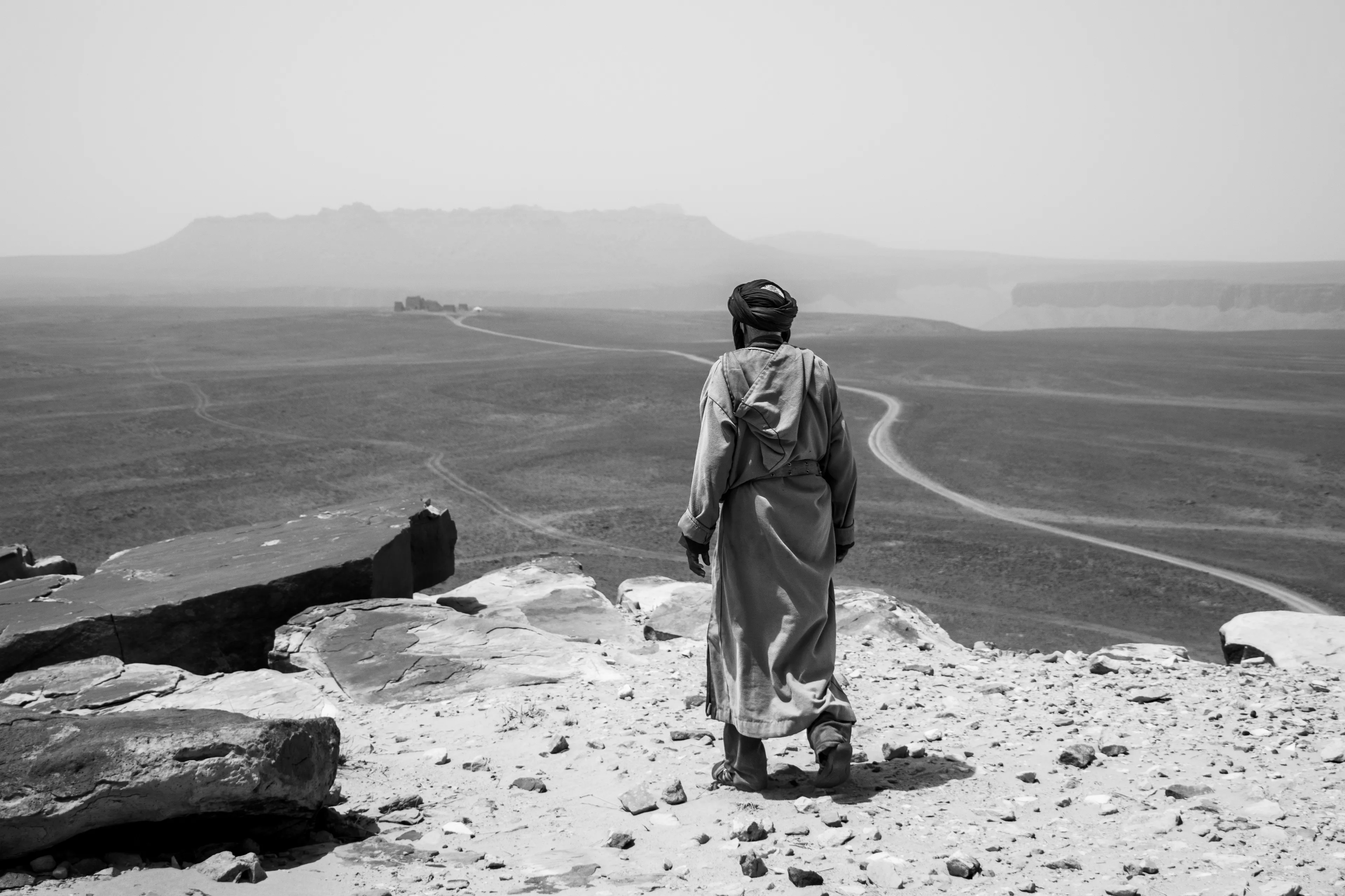 Looking high above the valley, a man observes the path to Fort Saganne, the small fort built for the 1984 film of the same name directed by Alain Corneau. Its walls rise from the desert sands, a striking reminder of how cinema can leave a mark even in the vast, timeless Sahara.
