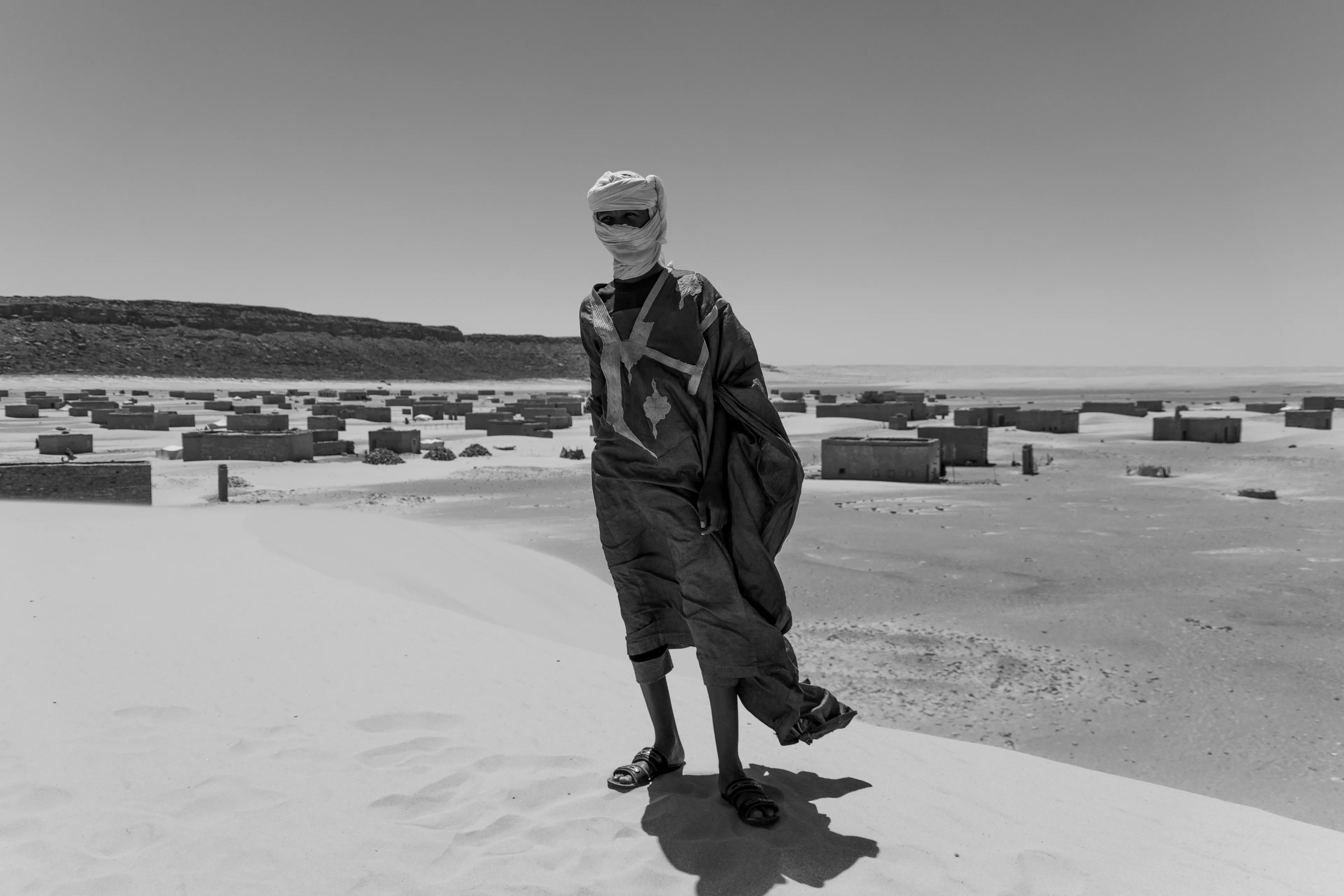 Akreijit in the background, its cliffs rising on the far left, one of the kids who had followed us all across the desert and up the mountain.
