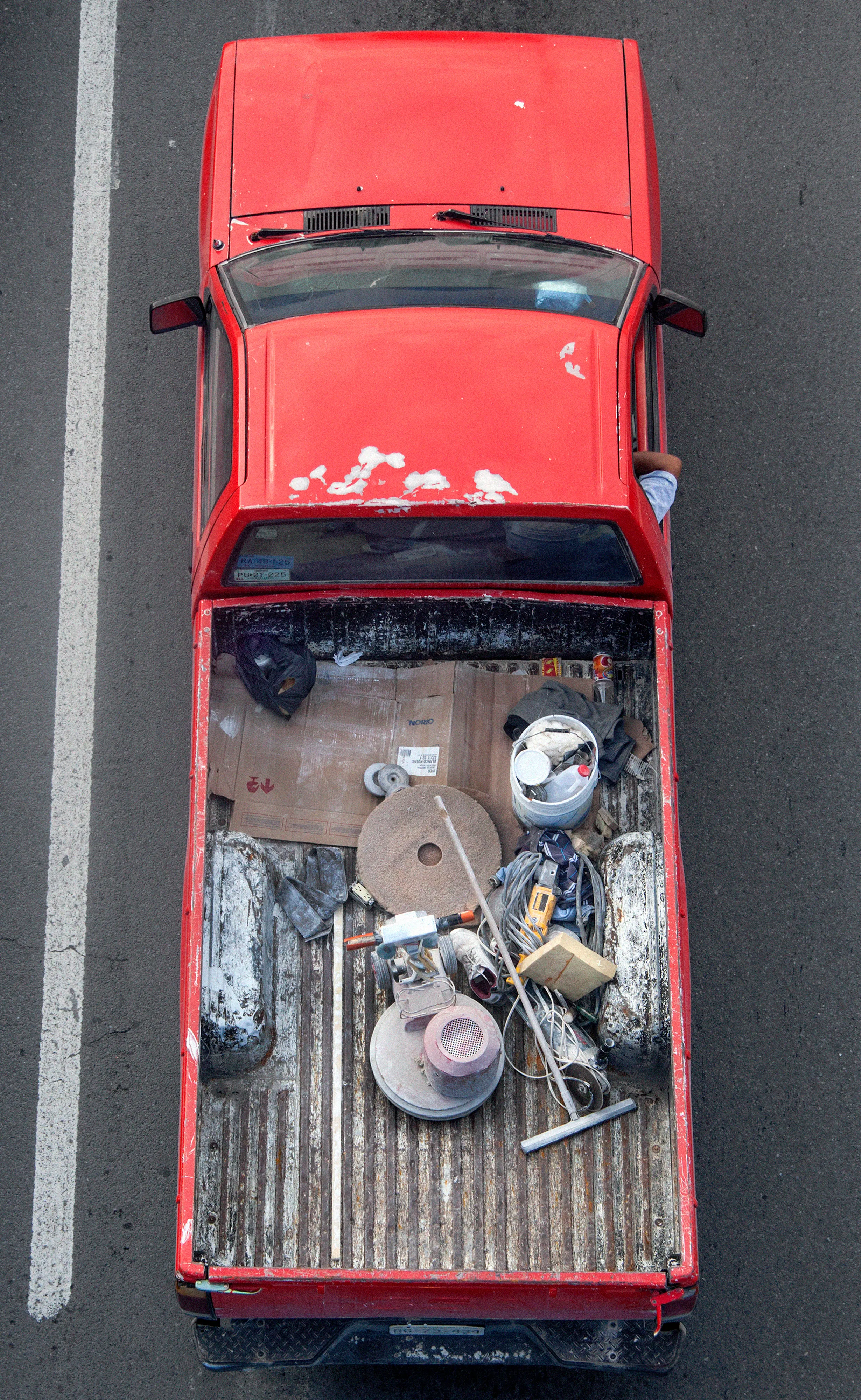 In Urban Transportation, Cartagena focuses on various modes of transportation used by workers in urban environments, particularly highlighting the ubiquitous red trucks. Shooting cars and trucks as they drive to work in the morning, Cartagena has been able to capture a stunning snapshot of what is the daily routine of a city. The colors and textures of the vehicles and objects, mixed with the contemporary idea of customizing vehicles make for arresting imagery of a contemporary Mexican city.