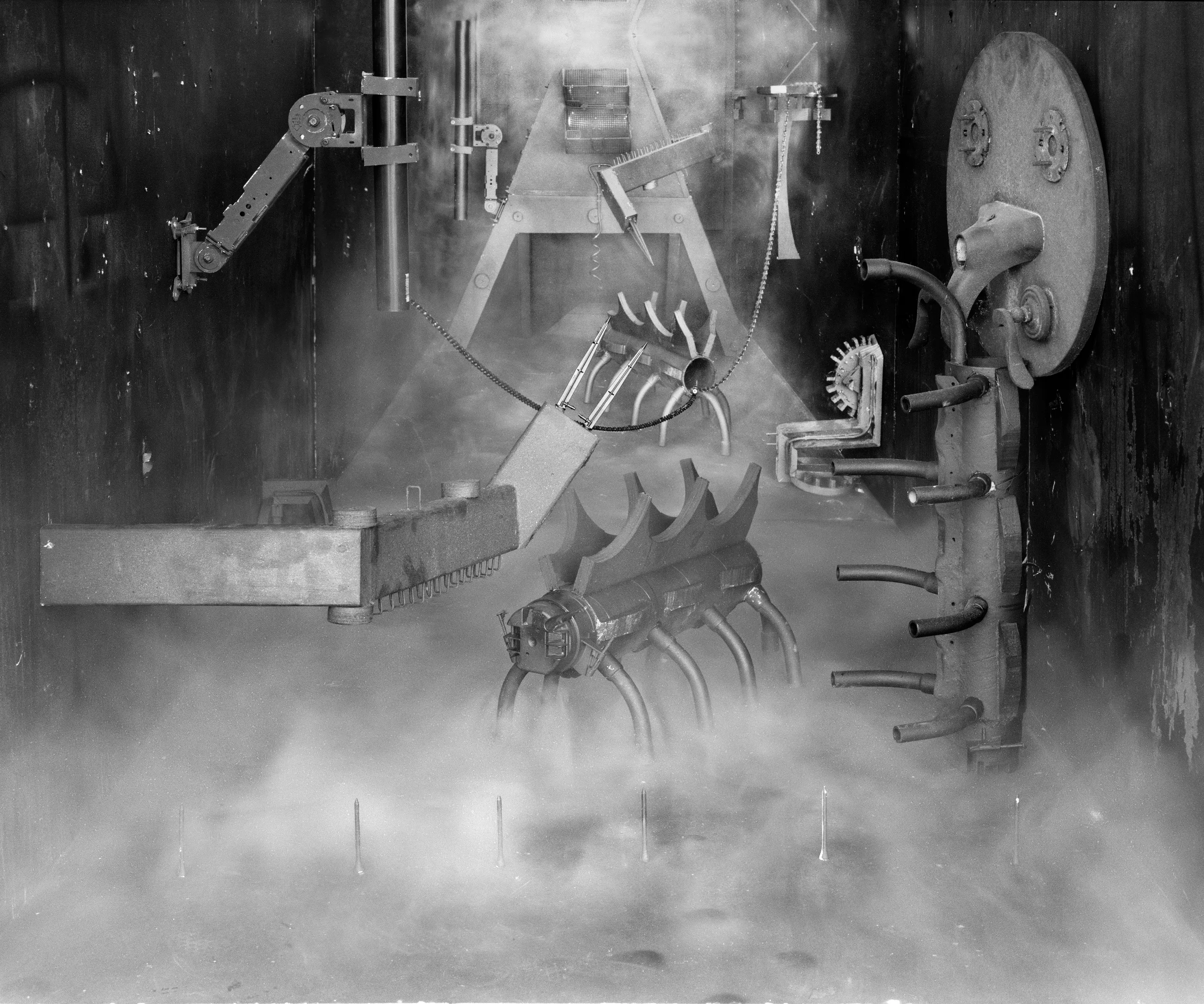 In conjunction with the exhibition in our physical gallery, Assembly presents “Afterwork” by Rodrigo Valenzuela. Based on the ghostly absence of workers in an indeterminate time and place, this work is at once futuristic and harking back to a century ago.

In staged sets suggesting abandoned factories, Valenzuela wishfully foments a revolution, enabling workers powerless in the face of relentless international movement of capital to flee or perhaps overrun their workplaces. As in a science-fiction universe where we feel a potential reality just out of reach of our present, Valenzuela’s scenes meld mechanical objects with steam or smoke, suggestive of steel manufacturing, a cloud of sweat-the only bodily proof of human toil-or a cinematic trope of futuristic atmosphere. In these eerily depopulated scenes, viewers are prompted to envision alternative possibilities to histories of workers dispossessed, or made obsolete, and industries that thrived on human pain.

Rodrigo Valenzuela is a Chilean-born, Los Angeles-based artist working in photography, video, painting, and installation. Not satisfied with the existing romanticism of blight and resurrection, Valenzuela opts for image making that is defiantly labor intensive and ambitious in scope. Detritus and industrial parts are scavenged over time, taken apart or reassembled, and transformed in the artist's own studio backdrops, then turned into flat images that confuse the viewer with scale shifts and multiple references. Using autobiographical threads to inform larger universal fields of experience, his work constructs narratives, scenes, and stories that point to the tensions found between the individual and communities. Much of his work deals with the experience of undocumented immigrants and laborers. His work has been exhibited internationally, including solo exhibitions at Lisa Kandlhofer Galerie, Vienna; the Ulrich Museum of Art, Wichita, KS; the Art Museum of the University of Memphis, TN; Klowdenmann Gallery, Los Angeles; the Frye Art Museum, Seattle; and Museo de Arte Contemporaneo, Santiago, Chile. In 2021, Valenuzlea was awarded a Guggenheim Fellowship in Photography and Smithsonian Artist Research Fellowship.