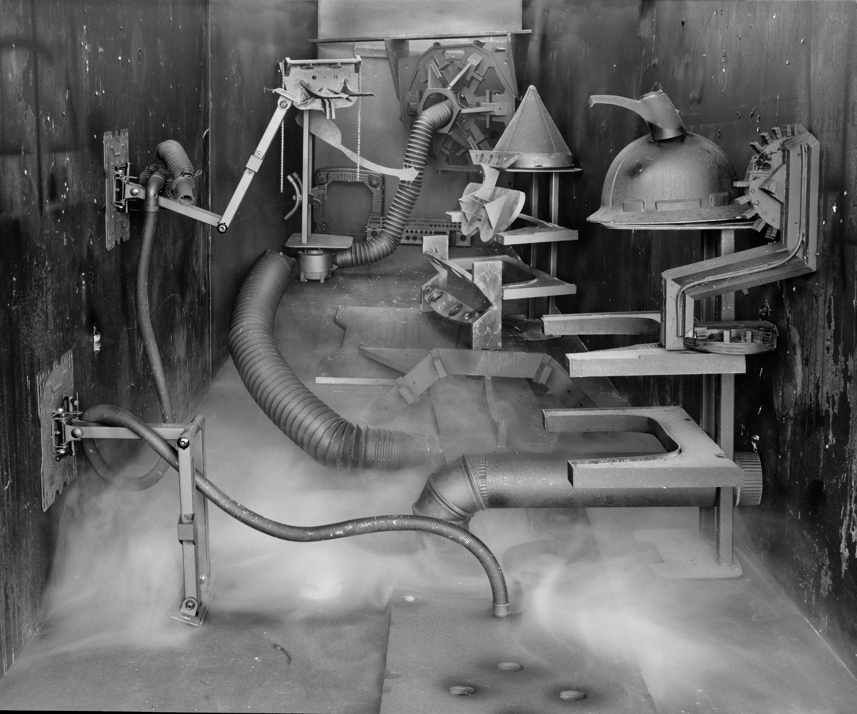 In conjunction with the exhibition in our physical gallery, Assembly presents “Afterwork” by Rodrigo Valenzuela. Based on the ghostly absence of workers in an indeterminate time and place, this work is at once futuristic and harking back to a century ago.

In staged sets suggesting abandoned factories, Valenzuela wishfully foments a revolution, enabling workers powerless in the face of relentless international movement of capital to flee or perhaps overrun their workplaces. As in a science-fiction universe where we feel a potential reality just out of reach of our present, Valenzuela’s scenes meld mechanical objects with steam or smoke, suggestive of steel manufacturing, a cloud of sweat-the only bodily proof of human toil-or a cinematic trope of futuristic atmosphere. In these eerily depopulated scenes, viewers are prompted to envision alternative possibilities to histories of workers dispossessed, or made obsolete, and industries that thrived on human pain.

Rodrigo Valenzuela is a Chilean-born, Los Angeles-based artist working in photography, video, painting, and installation. Not satisfied with the existing romanticism of blight and resurrection, Valenzuela opts for image making that is defiantly labor intensive and ambitious in scope. Detritus and industrial parts are scavenged over time, taken apart or reassembled, and transformed in the artist's own studio backdrops, then turned into flat images that confuse the viewer with scale shifts and multiple references. Using autobiographical threads to inform larger universal fields of experience, his work constructs narratives, scenes, and stories that point to the tensions found between the individual and communities. Much of his work deals with the experience of undocumented immigrants and laborers. His work has been exhibited internationally, including solo exhibitions at Lisa Kandlhofer Galerie, Vienna; the Ulrich Museum of Art, Wichita, KS; the Art Museum of the University of Memphis, TN; Klowdenmann Gallery, Los Angeles; the Frye Art Museum, Seattle; and Museo de Arte Contemporaneo, Santiago, Chile. In 2021, Valenuzlea was awarded a Guggenheim Fellowship in Photography and Smithsonian Artist Research Fellowship.