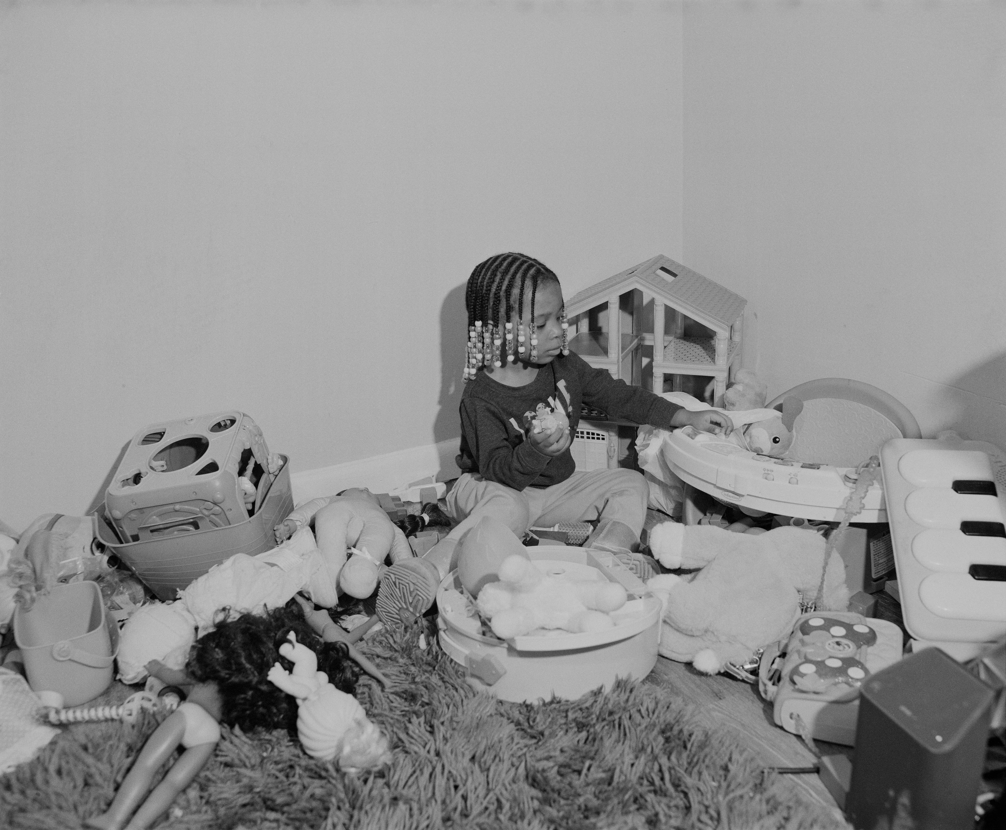It's Expensive to be Poor #7 Bob's Oldest by Hannah Price

I wanted to create a project on the costs of being poor. About how the U.S. system and bills keep the poor behind and dig a deeper hole in their life. In my research, I found a single mother of 32 years being neglected by affordable housing: Lisa McKine.

I first saw Lisa on a Philly Instagram page called nogunzone; it reposts police news and share reports from people in the community. I find it more informative than the local news, however I know several people who choose not to tune in for mental health reasons; it shows all the bad and we are currently on track to outdo last year’s homicide rate. 

Days after a tragic fire in another Philadelphia affordable housing apartment (PHA) that killed 12 people, a social media trend began with videos of people sharing themselves holding burning cigarettes near a silent smoke alarm. One in particular caught my eye, Lisa’s video of her son, telling him to wake up as a bunch of flies flew off his face.

Lisa did not grow up poor, she was raised by her dad and stepmother. Her dad worked for Philly managing janitorial duties in the courthouse. Her parents separated when she was young and it wasn’t until her 20’s when she learned bad habits from her biological mother of working the system. Lisa found herself a single mother of 2 and living in her first apartment of PHA affordable housing for ten years.

Lisa’s brother, Raul Gore (Bobby, 27) is currently on probation and has dealt with his own circumstances. He told me about the decisions he made in his early twenties that put him in and out of jail. He knows he can’t change how irresponsible he was but is now enjoying life with his family and providing for them. He works during the week and his wife on the weekends, they take turns watching their children. The environment Bobby grew up in at a younger age was surrounded by cops who watched him and his friends go to and from school. He remembers having fun with the cops by making them chase him and his friends. 

My first visit to Lisa’s place was at the beginning of March. There was an exterminator outside her building with hoses hooked up to an apartment on the second floor. Inside her apartment I noticed a particular odor and counted at least two roaches and one dead in the kitchen cabinet. Lisa had been complaining about the roach infestation to PHA since 2020, sharing records of failed exterminations and the summer of 2021 is when the flies started. The infestation has forced her to live out of bins and plastic bags. PHA exterminates the apartment every month and denies Lisa from moving to a new place. 

While photographing Lisa, I learned she has an associate in Applied Science in Construction Management from the college I work at. We crossed paths in 2018 but never met each other. Sharing personal frustrations, we spent a lot of time together as we both needed someone to just hear us and provide emotional support. Her boys Zaahir (11) and Quamir (5) are well behaved, social and sweet. Lisa provides for them all by driving Uber, bartering with her community, making and selling her own hair and skin products, as well as providing different hair services and body contouring.  

Luckily, Lisa found help to make a few months' deposit on rent for a new house outside of affordable housing. Through her 4 businesses, she plans to cover her rent of $2500. Lisa’s new house windows will help with her mood and knowing her dad is 13 minutes away in a nursing home should relieve some stress. Lisa’s dad had a stroke, causing bleeding in the brain which forced him to remove the left side of his brain. Her step mother also had brain surgery due to a horrible fall, and now both her parents are bed ridden while they recover from surgery.

Witnessing Lisa’s life, I imagined myself in her situation. A single mother unhappy in an infested home, barely getting by where the only way out is taking a huge risk renting a house not knowing she can afford it. The point of this NFT is to give back to the community, specifically Lisa so I have shared Lisa’s wallet address with you below.

The more time I spent with Lisa, the closer we became. We talked about dating and tried to provide emotional support for each other’s lives. I don’t become friends with all my subjects, but those who don’t have a problem expressing and sharing their feelings, I tend to share back. One day, I couldn’t help but break down crying and another day Lisa needed to as well. It was when we had planned to take the photograph in the window from the outside perspective that she was telling me how her dad was transferred to a different hospital. Wondering why, she demanded to see him and discovered he had a large infected bed sore that went up his back. From the photo, the scab looked at least 2’ long and 1’ wide with a fist sized faint sore. Why did they wait so long to tell Lisa? More neglect. Lisa would love to take care of him herself if she had known. In the end, Lisa still wanted to make the photograph, she wanted to keep her promise and help me with my project. I said no, but ultimately gave in even though it was completely dark out. My plan was to catch the sun setting. However, life isn’t what we plan it to be. During the photo, I could hear Lisa praying to God and her ancestors, full of sadness, hope and joy. 

To keep up with Lisa, follow her on Instagram @lovelylisa215, @hollywoodglamour.co, @mckine_building_group

Donate ether to Lisa’s address:  0x0cE11858dc7f01E6c2bEB9d1f2F6cb273484076e

Edition: 1 of 1

Commissioned by Obscura