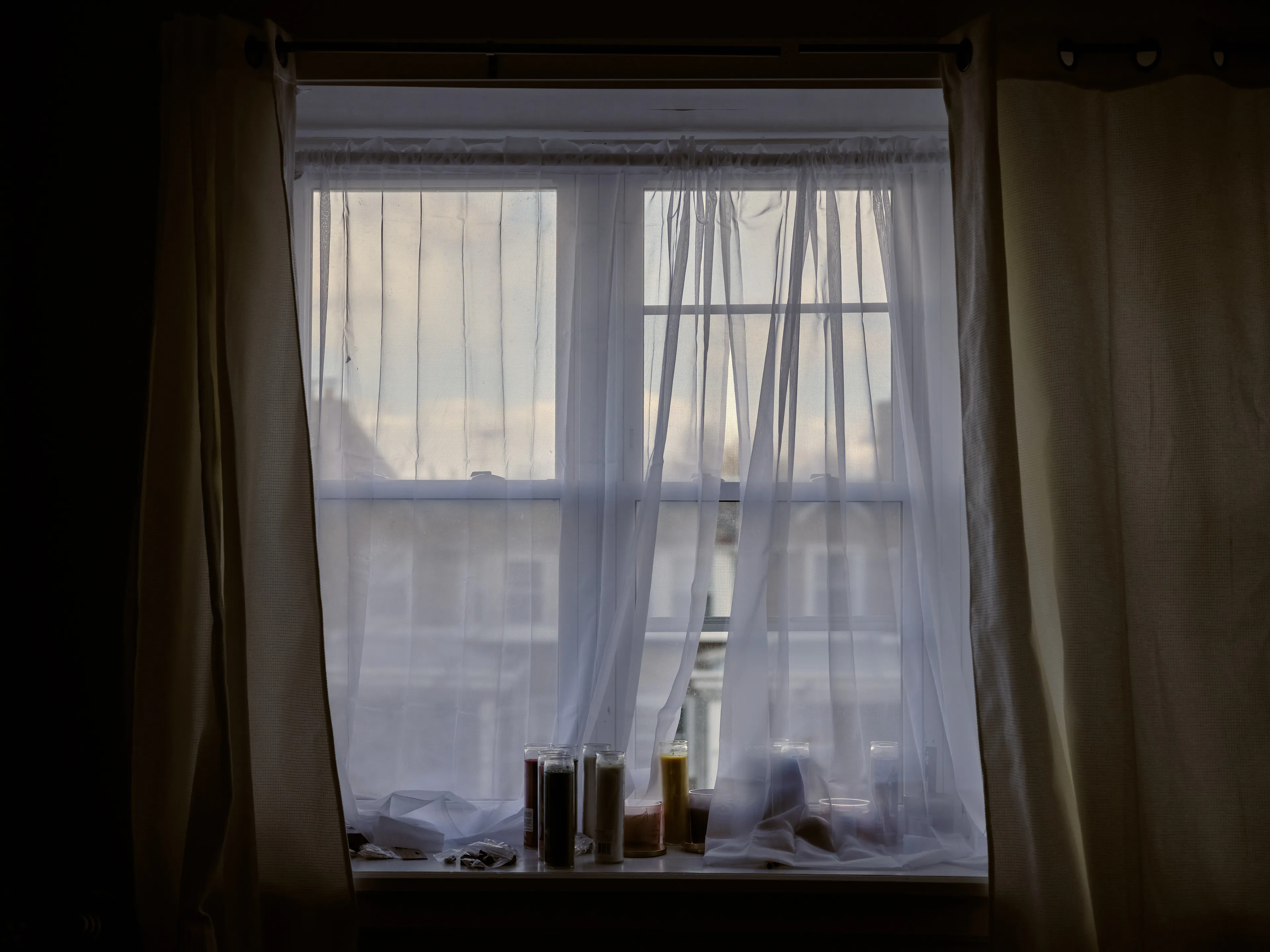 It's Expensive to be Poor #34 Lisa's New Window by Hannah Price

I wanted to create a project on the costs of being poor. About how the U.S. system and bills keep the poor behind and dig a deeper hole in their life. In my research, I found a single mother of 32 years being neglected by affordable housing: Lisa McKine.

I first saw Lisa on a Philly Instagram page called nogunzone; it reposts police news and share reports from people in the community. I find it more informative than the local news, however I know several people who choose not to tune in for mental health reasons; it shows all the bad and we are currently on track to outdo last year’s homicide rate. 

Days after a tragic fire in another Philadelphia affordable housing apartment (PHA) that killed 12 people, a social media trend began with videos of people sharing themselves holding burning cigarettes near a silent smoke alarm. One in particular caught my eye, Lisa’s video of her son, telling him to wake up as a bunch of flies flew off his face.

Lisa did not grow up poor, she was raised by her dad and stepmother. Her dad worked for Philly managing janitorial duties in the courthouse. Her parents separated when she was young and it wasn’t until her 20’s when she learned bad habits from her biological mother of working the system. Lisa found herself a single mother of 2 and living in her first apartment of PHA affordable housing for ten years.

Lisa’s brother, Raul Gore (Bobby, 27) is currently on probation and has dealt with his own circumstances. He told me about the decisions he made in his early twenties that put him in and out of jail. He knows he can’t change how irresponsible he was but is now enjoying life with his family and providing for them. He works during the week and his wife on the weekends, they take turns watching their children. The environment Bobby grew up in at a younger age was surrounded by cops who watched him and his friends go to and from school. He remembers having fun with the cops by making them chase him and his friends. 

My first visit to Lisa’s place was at the beginning of March. There was an exterminator outside her building with hoses hooked up to an apartment on the second floor. Inside her apartment I noticed a particular odor and counted at least two roaches and one dead in the kitchen cabinet. Lisa had been complaining about the roach infestation to PHA since 2020, sharing records of failed exterminations and the summer of 2021 is when the flies started. The infestation has forced her to live out of bins and plastic bags. PHA exterminates the apartment every month and denies Lisa from moving to a new place. 

While photographing Lisa, I learned she has an associate in Applied Science in Construction Management from the college I work at. We crossed paths in 2018 but never met each other. Sharing personal frustrations, we spent a lot of time together as we both needed someone to just hear us and provide emotional support. Her boys Zaahir (11) and Quamir (5) are well behaved, social and sweet. Lisa provides for them all by driving Uber, bartering with her community, making and selling her own hair and skin products, as well as providing different hair services and body contouring.  

Luckily, Lisa found help to make a few months' deposit on rent for a new house outside of affordable housing. Through her 4 businesses, she plans to cover her rent of $2500. Lisa’s new house windows will help with her mood and knowing her dad is 13 minutes away in a nursing home should relieve some stress. Lisa’s dad had a stroke, causing bleeding in the brain which forced him to remove the left side of his brain. Her step mother also had brain surgery due to a horrible fall, and now both her parents are bed ridden while they recover from surgery.

Witnessing Lisa’s life, I imagined myself in her situation. A single mother unhappy in an infested home, barely getting by where the only way out is taking a huge risk renting a house not knowing she can afford it. The point of this NFT is to give back to the community, specifically Lisa so I have shared Lisa’s wallet address with you below.

The more time I spent with Lisa, the closer we became. We talked about dating and tried to provide emotional support for each other’s lives. I don’t become friends with all my subjects, but those who don’t have a problem expressing and sharing their feelings, I tend to share back. One day, I couldn’t help but break down crying and another day Lisa needed to as well. It was when we had planned to take the photograph in the window from the outside perspective that she was telling me how her dad was transferred to a different hospital. Wondering why, she demanded to see him and discovered he had a large infected bed sore that went up his back. From the photo, the scab looked at least 2’ long and 1’ wide with a fist sized faint sore. Why did they wait so long to tell Lisa? More neglect. Lisa would love to take care of him herself if she had known. In the end, Lisa still wanted to make the photograph, she wanted to keep her promise and help me with my project. I said no, but ultimately gave in even though it was completely dark out. My plan was to catch the sun setting. However, life isn’t what we plan it to be. During the photo, I could hear Lisa praying to God and her ancestors, full of sadness, hope and joy. 

To keep up with Lisa, follow her on Instagram @lovelylisa215, @hollywoodglamour.co, @mckine_building_group

Donate ether to Lisa’s address:  0x0cE11858dc7f01E6c2bEB9d1f2F6cb273484076e

Edition: 1 of 1

Commissioned by Obscura