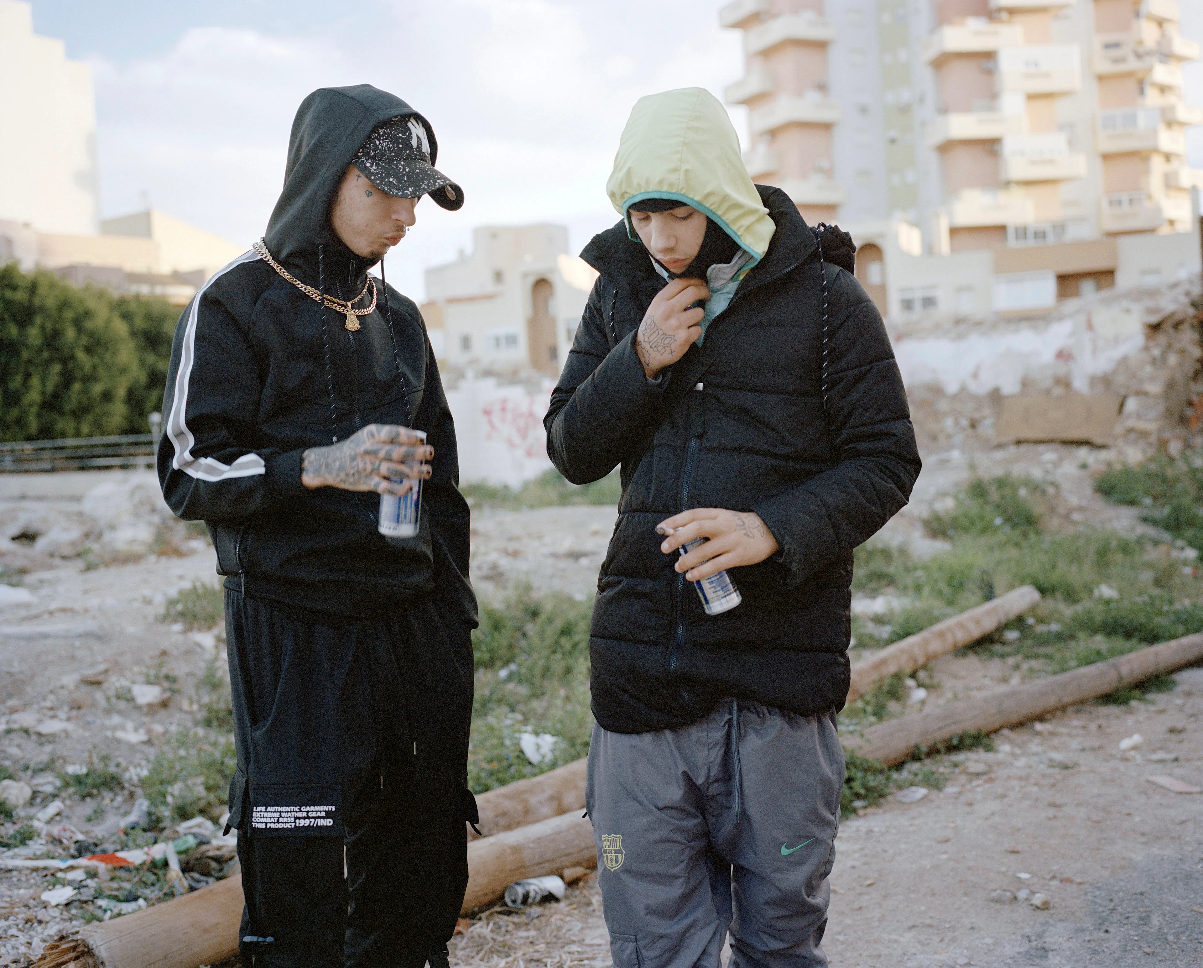 Agony In The Garden #18 by Lúa Ribeira

Kidflako Elceropunto

This series was made in various cities across the Spanish territory in collaboration with young people involved in the emerging Trap and Drill music scene.

Both genres originated in the United States as an evolution of rap music and have transcended their initial context to become globally influential movements with local scenes emerging across the world (Spain, France, Italy, Australia, Ghana, Sweden, (.))

The music is often recognized for the nihilistic lyrical content and portraying a duality between a precarious life and one of luxury and fame that becomes tangible within the global-digital-online arena. It is the hedonism versus nihilism, the darkness versus joy, the glorification of wealth and banalization of violence that resonate as a response to the values, markets and structures within contemporary society in late capitalism.

In Spain -a country with the highest youth unemployment rate in Europe- drill has become the first cultural boom that is not predominantly white. It is in cities like Madrid, Almeria or Granada where younger generations are exploring the music and the aesthetic of trap and drill and making it their own.

Often represented as apolitical, performative, or superficial, my aim with the work is to read between the lines, to reflect on the emancipatory potential of a mainstream expression of our time and how it relates to the present context of a precarious job market, institutional violence, migratory, financial and environmental crisis.

Embracing a performative collaboration that is integral to my work, I focussed on a series of gestures and landscapes to try and capture an atmosphere, hoping to transcend the idea of subculture and consider its value from a more enrooted perspective.

Edition: 1 of 1

Commissioned by Obscura