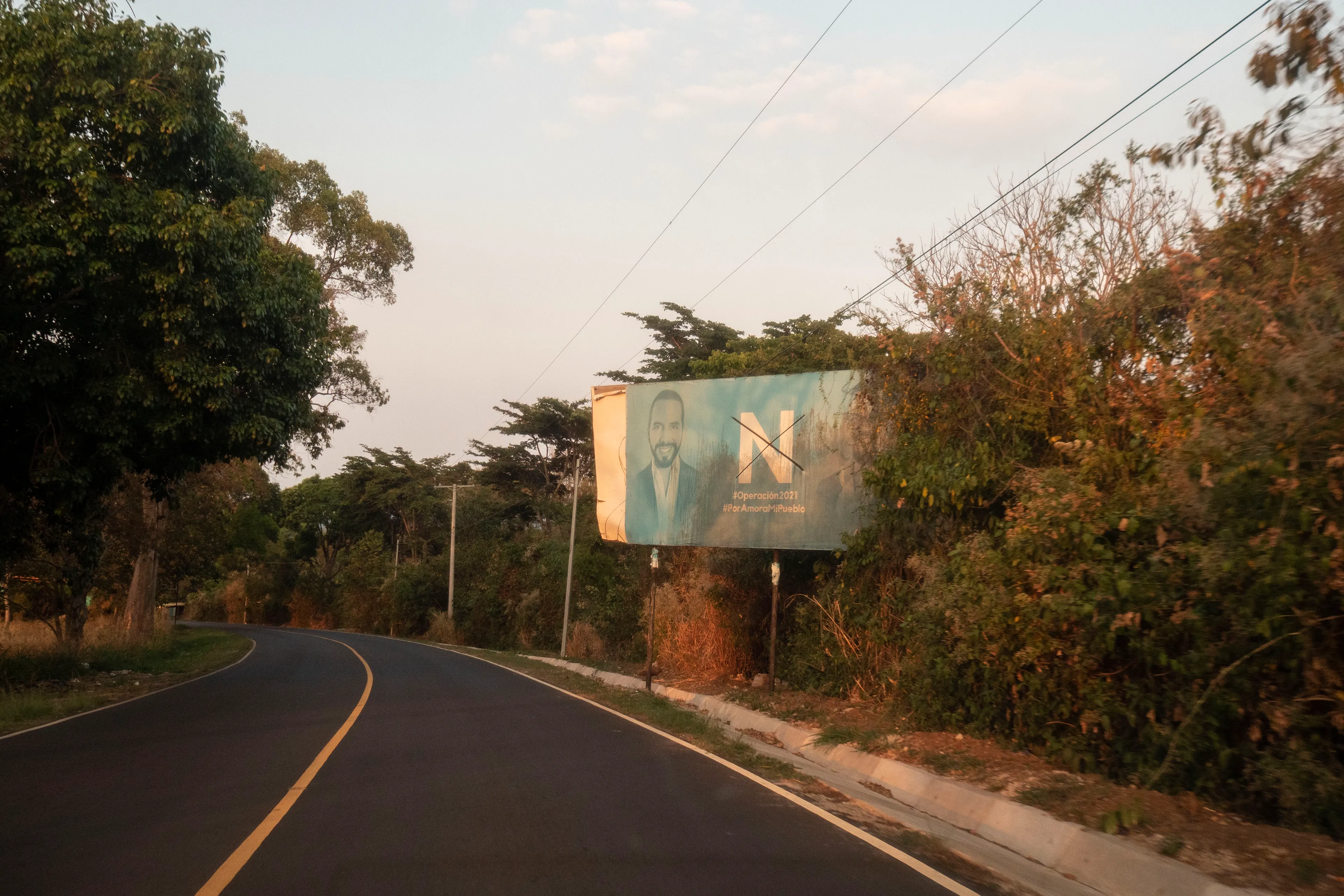 « Bitcoin Nation » #32 by Thomas Dworzak

EL SALVADOR, San Salvador, 2022/3-4. On the slopes of the Santa Ana Volcano. President Nayib Bukele poster.

« Bitcoin Nation » - El Salvador - Thomas Dworzak / Magnum Photos

Many photographers and journalists of my generation, interested in war and conflict, would at one point read Richard Kapusciznsky's all-time classic "The Soccer War" and watch Oliver Stone's "Salvador. » The latternow feels insanely cheesy. With the country's troubled history in mind and never having been to Central America, I found "Bitcoin Nation - El Salvador" a challenging theme to explore for this NFT project. 

I set out to straightforwardly document this alien and invisible world of bitcoin, and being 'in the realm of crypto,' I hoped it would give me access to President Nayib Bukele's surprise project. Last year he had suddenly declared Bitcoin the official currency of El Salvador - which until now was only the US dollar. The 40-year-old president of Palestinian origin started out as an anti-establishment candidate, describing himself as "the world's coolest dictator," but soon took an authoritarian turn. Yet he continues drumming the bitcoin beat, and bitcoin celebrities from all around the world keep flocking to El Salvador.
The Pacific beach town of El Zonte became "Bitcoin Beach," and "Volcano Bonds" and "Bitcoin City" are meant to be the future.

When official doors remained closed for me, I started digging for clues in the county's troubled past and present or anything, even remotely, related to the bitcoin world. Vignettes of the bloody civil war regularly popped up, and I came across a few "bitcoin events." The sudden spike of almost a hundred homicides in the course of one weekend in late March, due to what seemed a breakdown of a secret deal between the government and the two main gangs, had President Bukele declare a state of emergency, martial law and intensify the war on the gangs. I could see fringes of it. But nothing compared to the brutality of
the spectacularly filmed daily government propaganda videos of mass arrests and more-than-rough prisoner handlings I watched on TV, Twitter, and Instagram.

It was at a small bitcoin event that I found a hint why I may have been shunned and didn't get any access to show the "shiny world of Bitcoin Nation," as I had hoped. My NFT ticket was definitely the "wrong church" in the Bitcoin world. To paraphrase one of the speakers: "If I want to gamble, I go to Vegas and party with beautiful hookers, instead of being a loser, sitting around in my basement, frustrated, minting NFTs. Shitcoins."

El Salvador and the President were meant to be guests of honor at the Bitcoin 2022 conference in Miami. But due to the internal tension, he canceled the visit, and the 30+ thousand delegates had to discuss the future of bitcoin without him.

Edition: 1 of 1

Commissioned by Obscura