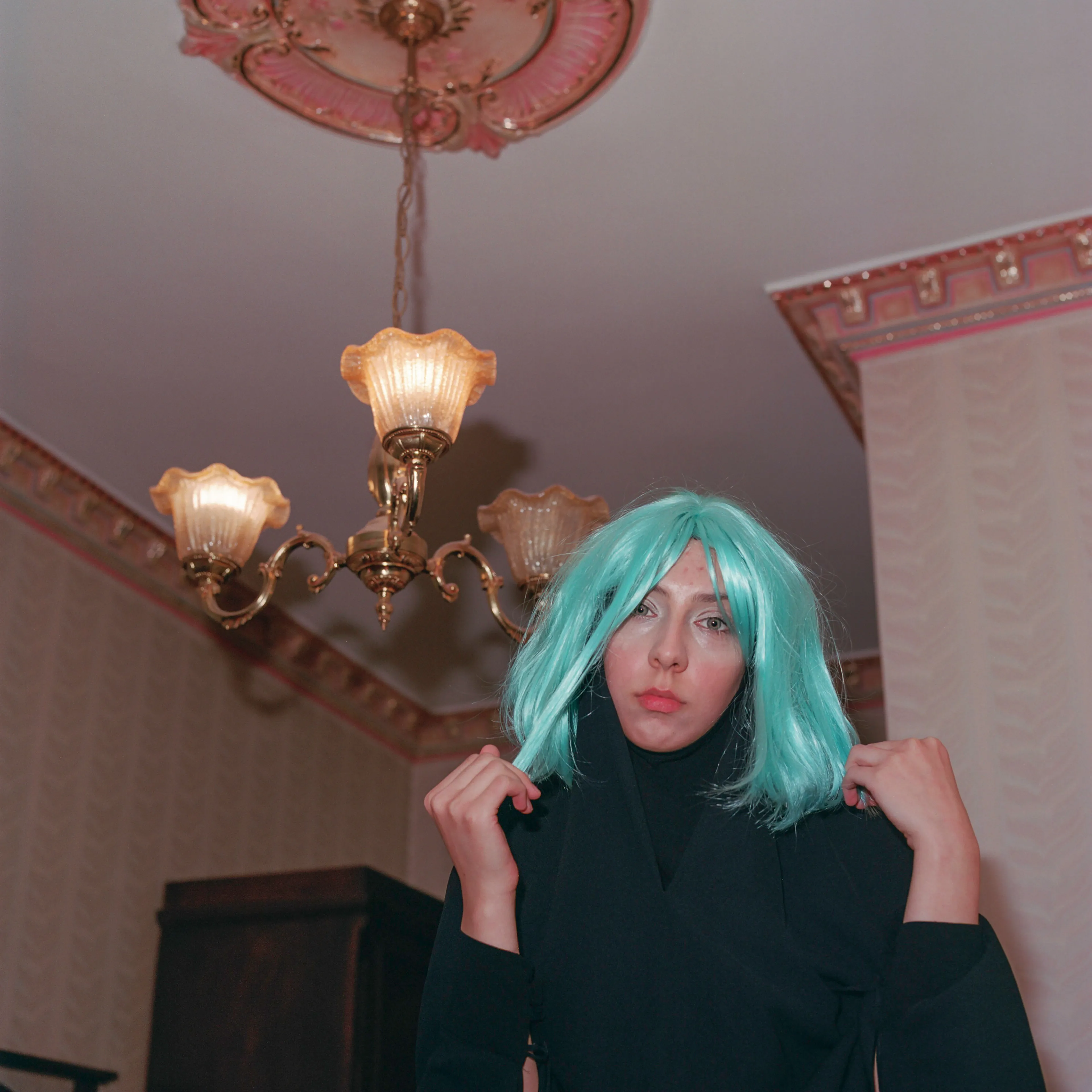 Transfiguration #31 by Sabiha Çimen

Şeyma with her blue wig. Istanbul, Turkey.

The impetus of this project grew out of my first book Hafız, about young girls who are memorizing Quran in schools through-out Turkey. Some marry and have children soon after graduation, but some rebel and transform themselves in a radical way; Şeyma is one of those stories of Transfiguration.

This is a world known to me because I too studied in a Quran school with my twin sister in Istanbul when I was younger.  When I returned to do my first long term photographic project l sought out familiar scenes and objects from my memory there and it was there that I met Şeyma and her unique and radical ways.

My projects usually deal with the Art of Resistance within my close circle of friends and family. In my last project the young girls' trivialities and playfulness took center stage, and now as these girls enter into adulthood they are faced with living in a world of male dominance. Sometimes, as with Şeyma, there is a need for revenge with their new found power over men and their money and habits; an inner strength coming from raw female intellect, and sexuality. 

This time my project not only focuses on the girls stories, but lies within the context of a large city- Istanbul, with its multiple layers and meanings. l am trying to provide the viewer cause and effect by viewing the different strata simultaneously and between. In the story Şeyma l am portraying her world, her fantasies, her fears, hidden love stories, songs and signs, ancient traditions, religious black-outs, and her continued spirituality that was never lost even through her Transfiguration. 


Edition: 1 of 1

Commissioned by Obscura