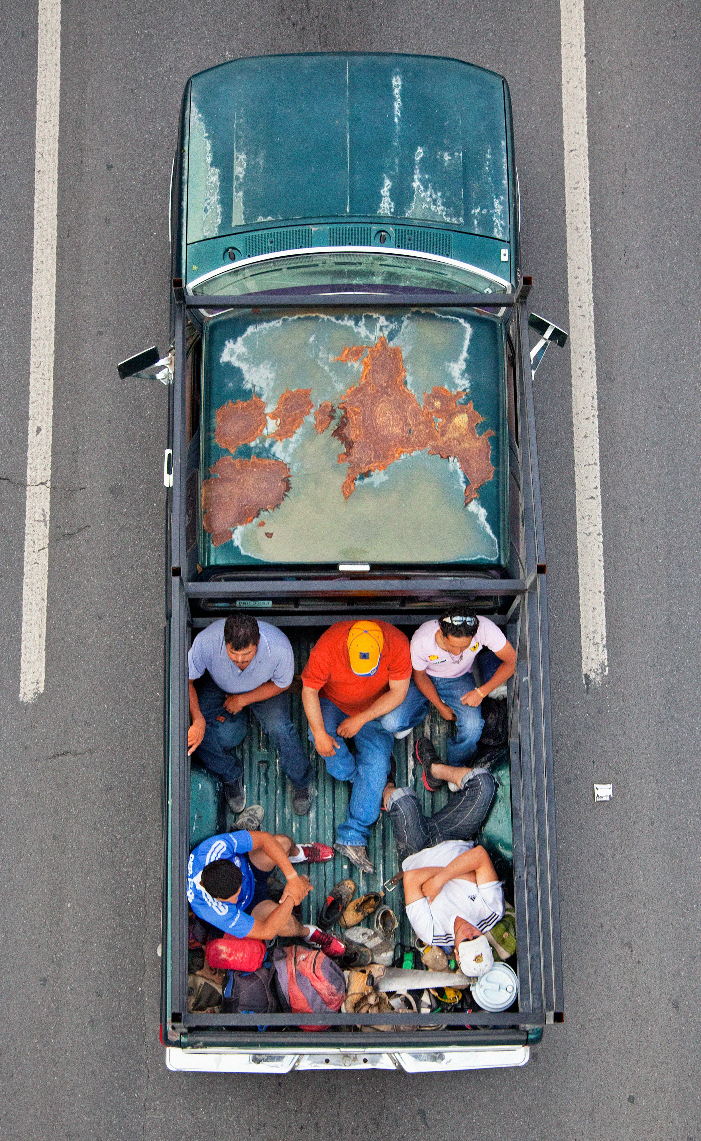 This photograph is part of my series, Carpoolers, which depicts laborers in México captured from an overpass, commuting between distant suburbs and urban centers. Like much of my work, this project comes from a desire to tell the story of the dramatic environmental, economic, and demographic changes playing out in my home city of Monterrey. This series has circulated the internet since 2011 and has been exhibited widely around the world.