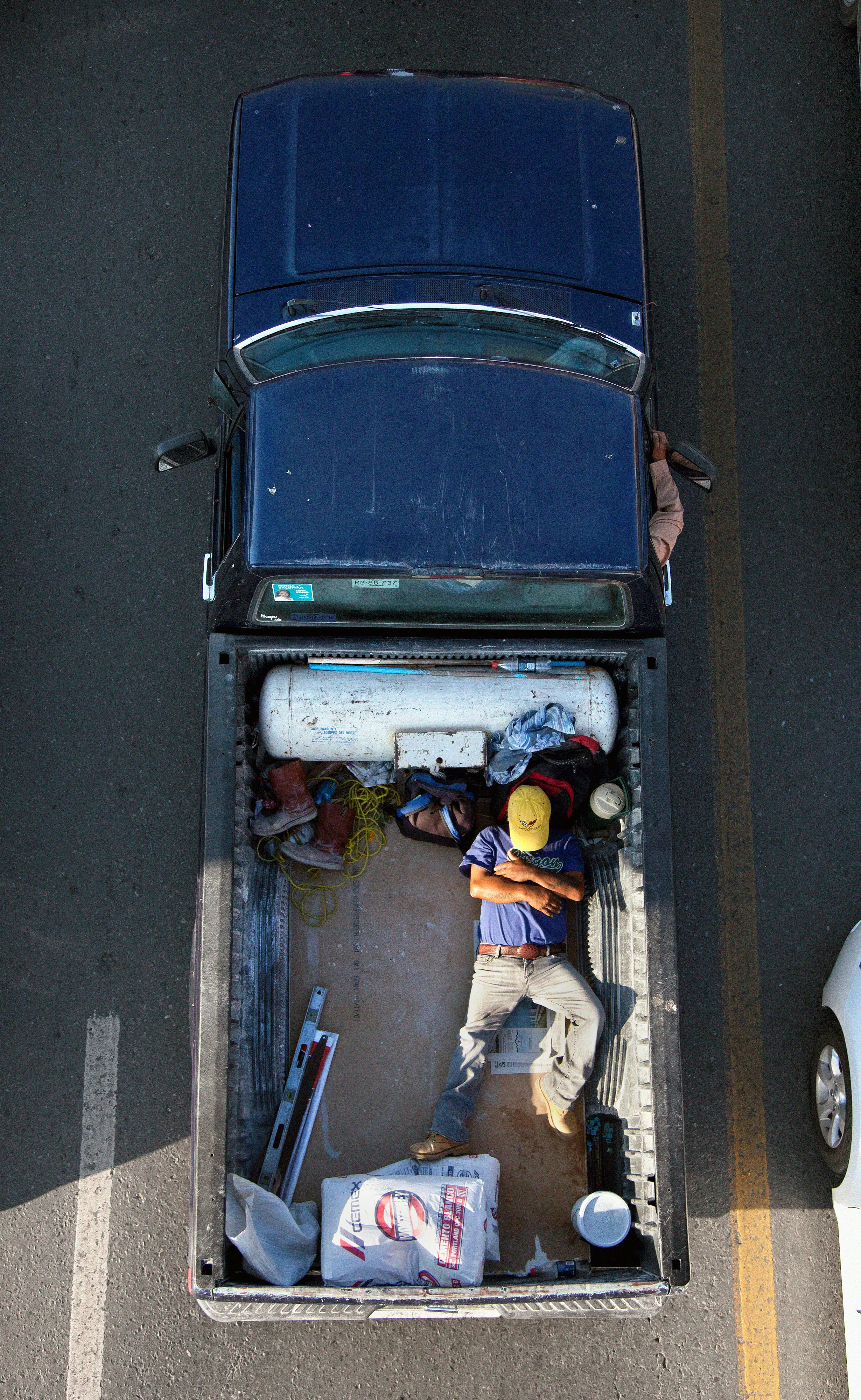 This photograph is part of my series, Carpoolers, which depicts laborers in México captured from an overpass, commuting between distant suburbs and urban centers. Like much of my work, this project comes from a desire to tell the story of the dramatic environmental, economic, and demographic changes playing out in my home city of Monterrey. This series has circulated the internet since 2011 and has been exhibited widely around the world.