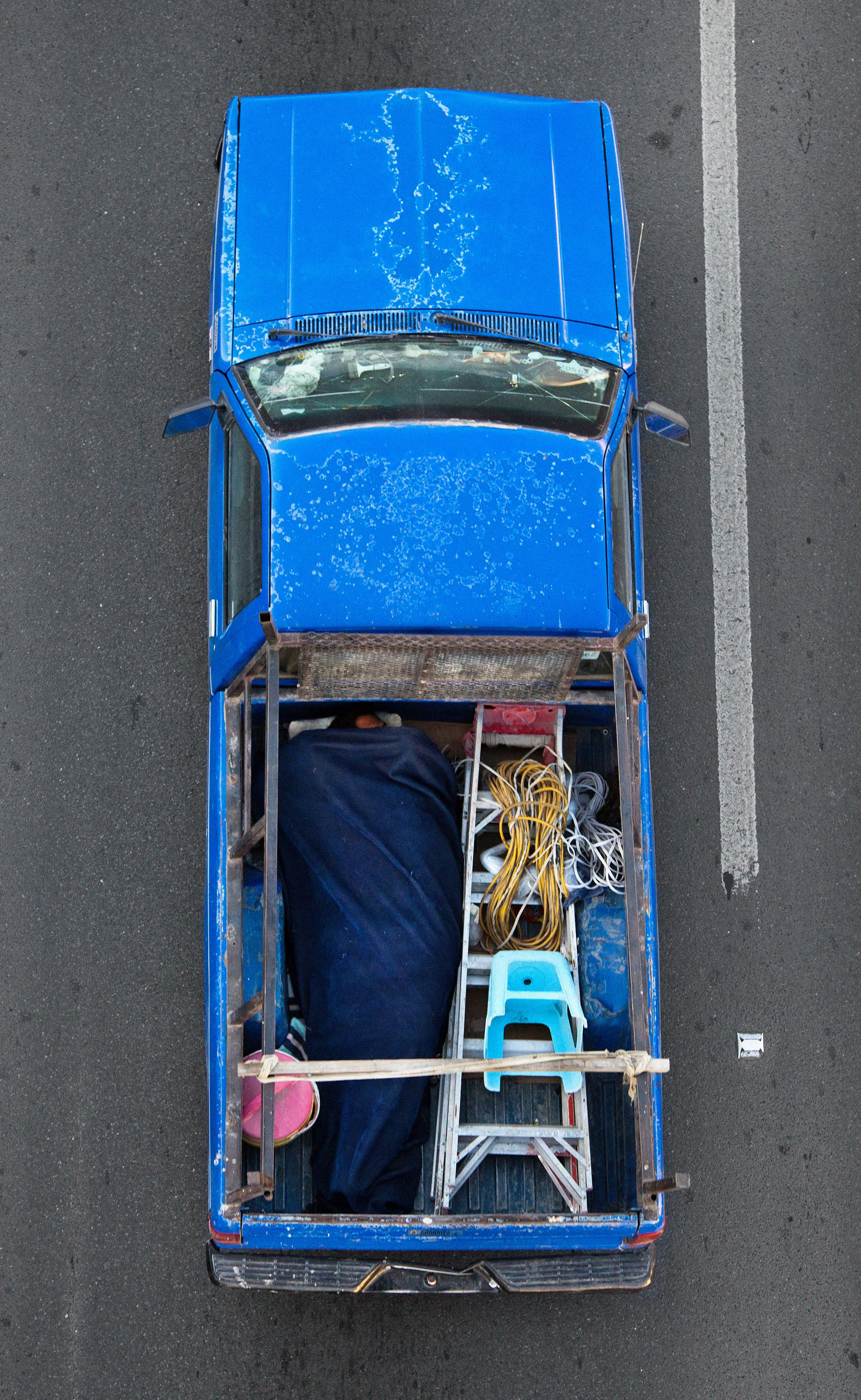 This photograph is part of my series, Carpoolers, which depicts laborers in México captured from an overpass, commuting between distant suburbs and urban centers. Like much of my work, this project comes from a desire to tell the story of the dramatic environmental, economic, and demographic changes playing out in my home city of Monterrey. This series has circulated the internet since 2011 and has been exhibited widely around the world.