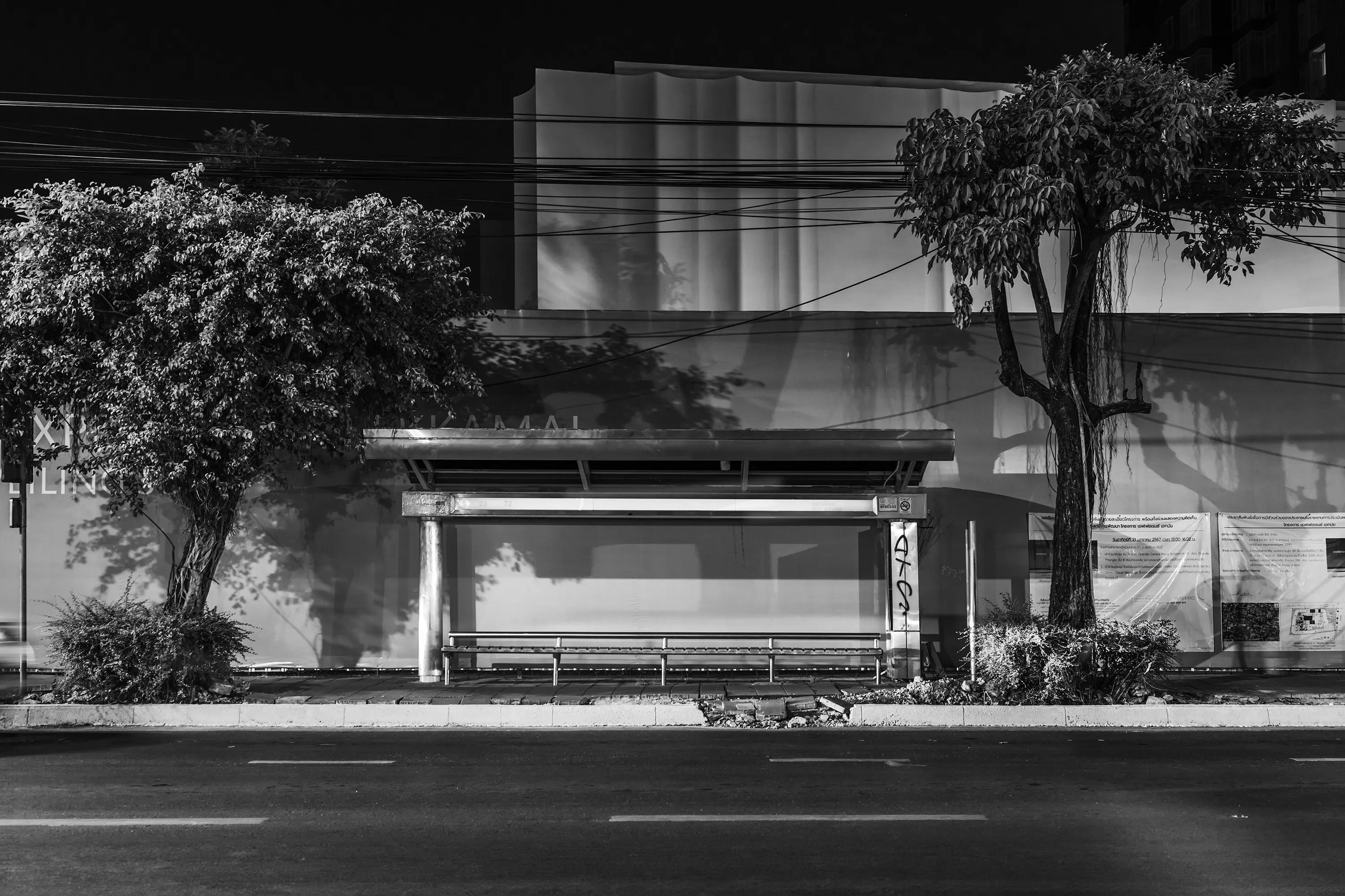 Beacon
The Sea #03

// The inception of the Beacon series traces back to a solitary photograph captured for the project "Portuguese Sea" by Bernardo Caria. Rooted in Fernando Pessoa's 1922 poem of the same title, the project delves into diverse interpretations of home. At its core, the sea symbolizes a wellspring of inspiration, exploration, and identity.

A year later, the poetic essence of Pessoa's verses metamorphosed into a lens-based art series titled Beacon. The expansive sea embodies boundlessness and promise, a stark contrast to the confines of urban living, particularly within sprawling megacities. Amidst the bustling metropolis, where individuals often feel lost amidst concrete canyons and a cacophony of noise, finding the tranquility Pessoa seeks in the sea proves elusive.

Yet, within the urban labyrinth, a languid light unveils the unseen and overlooked. Neon emanates from forsaken bus stop billboards, casting an ethereal glow reminiscent of coastal beacons. This luminous voyage through the cityscape evokes the hues of the sea—rugged and brilliant, evoking a longing for home. The tales of those setting out on their journeys remain shrouded in mystery to us; we merely glimpse them as they wait or vanish into the distance. It's only the illumination of the bus stop that hints at a narrative, leaving us to conjure the story within our imaginations.

Adding another layer to the series, documenting the fading Bangkok bus stops adorned with colossal backlit advertisements becomes a testament to identity and transition. As 2024 unfolds, these iconic structures are gradually supplanted by more economical and utilitarian counterparts, signaling an era's end.

At the core of the Beacon series lies photography, offering a distinctive 360º narrative journey that encompasses different media, presented in three parts - The Coast (mixed media), The Sea (photography), and The Wave (collectors reward airdrops) for, “Narratiff” with Colonna Contemporary.