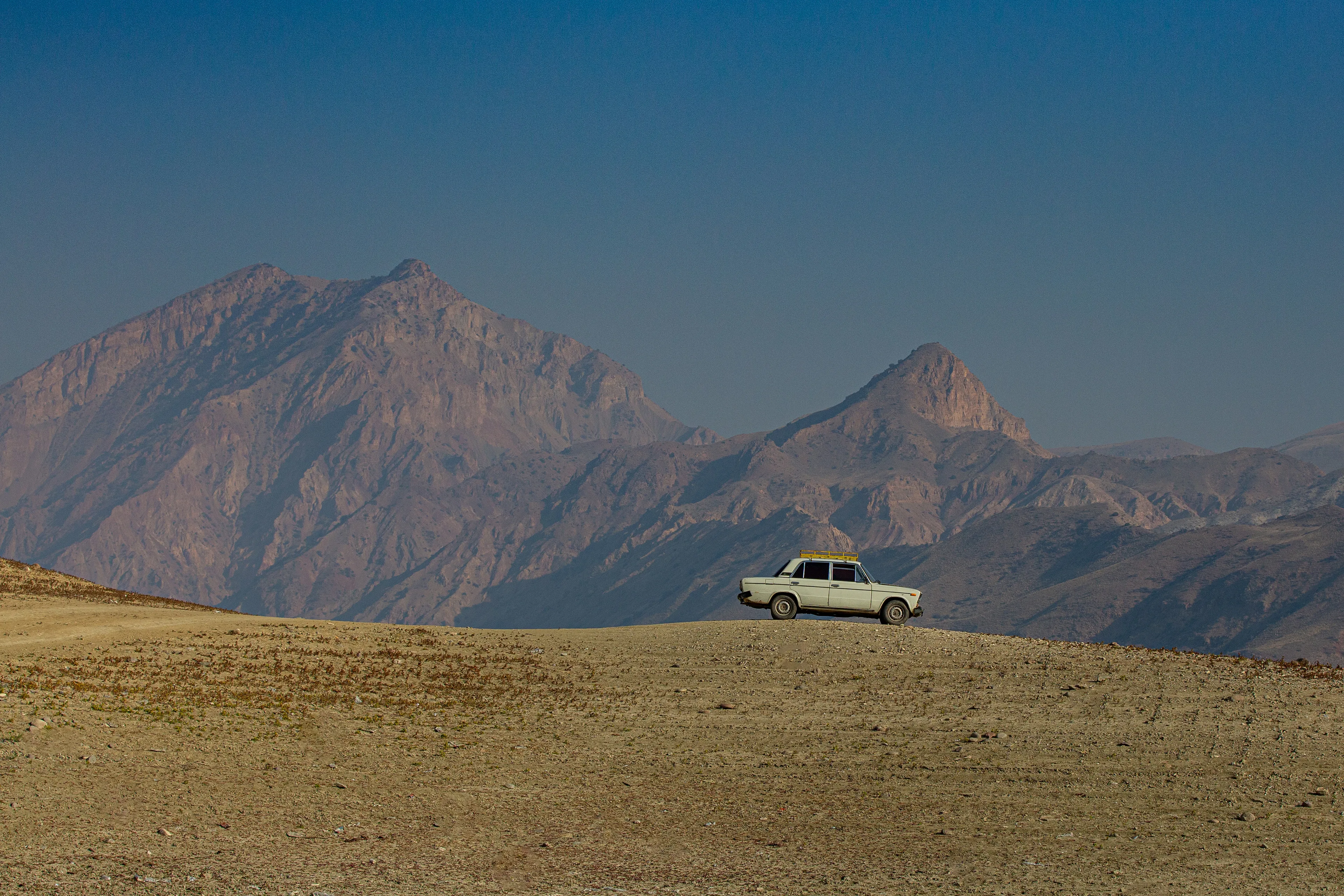 Scenic vista with mountains, a quaint hill, and the iconic Soviet VAZ 2106, beloved by fishermen and not only.

License:
The holder of this NFT is free to display the associated file privately and publicly, including in commercial and non-commercial settings, and in groups with an unlimited number of participants. The license includes unlimited use and displays in virtual or physical galleries, documentaries, and essays by the NFT holder. Provides no rights to create commercial merchandise, commercial distribution, or derivative works. Creator retains full commercial rights, including the right to produce and sell physical prints.

