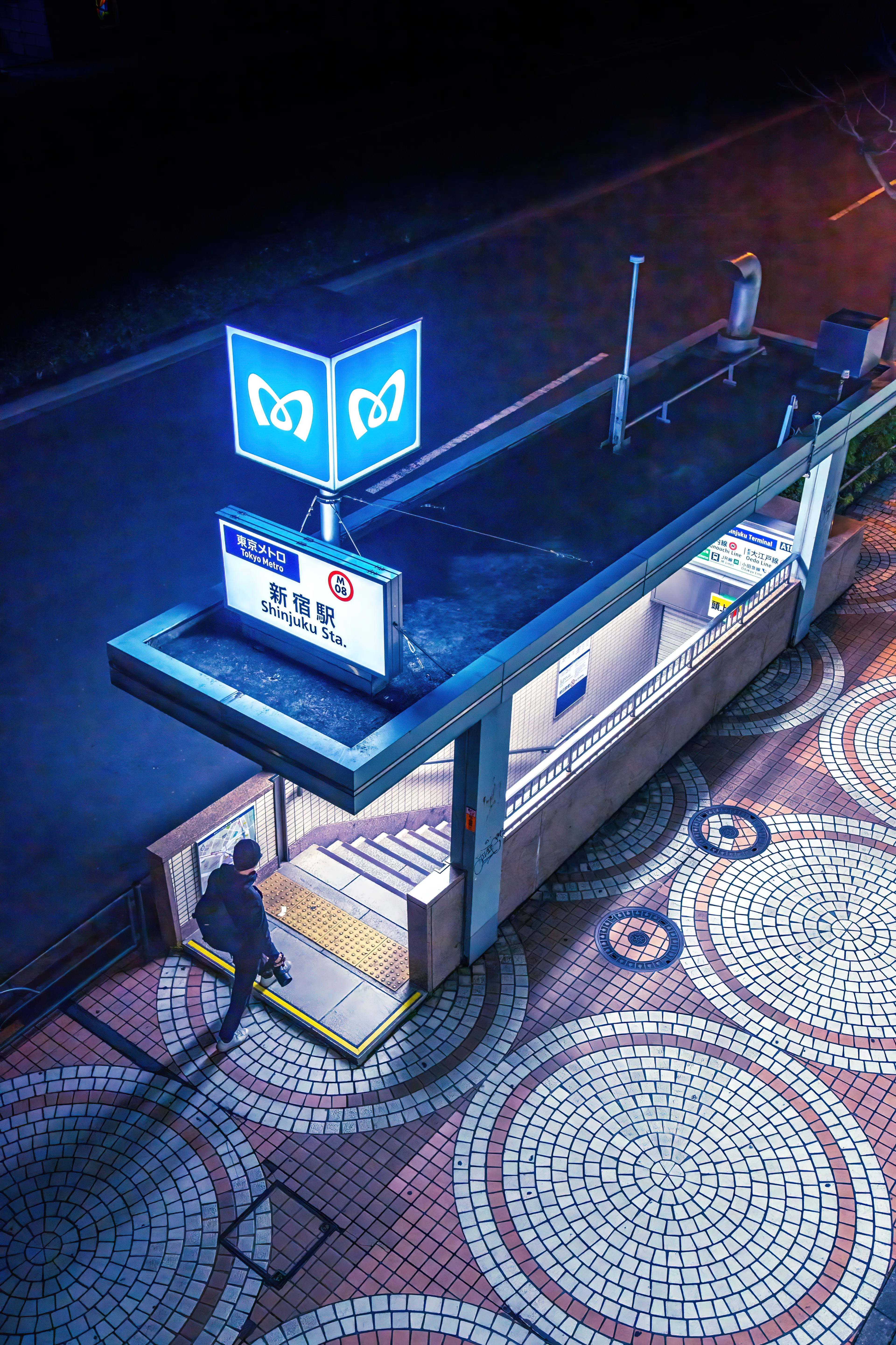           I spent many nights wandering the city of Tokyo at night. There were countless districts, but I spent the majority of my time exploring the streets of Shibuya and Shinjuku. One of the most iconic images of Tokyo I can think of is this shot of a Shinjuku Station exit that I took from an overpass.  
	 There is a small footbridge right above it that overlooks the exit. It is pretty easy to access. Whenever I think back to my nights in Tokyo, this is one of the images that I would choose to describe my trip there. I like the simplicity of having one light source in the darkness and having one person enter the light.
         Each of my 1/1s comes with commercial rights as well as a signed print. Please be sure to contact me for your print (prints only apply for the first person to collect a piece.)