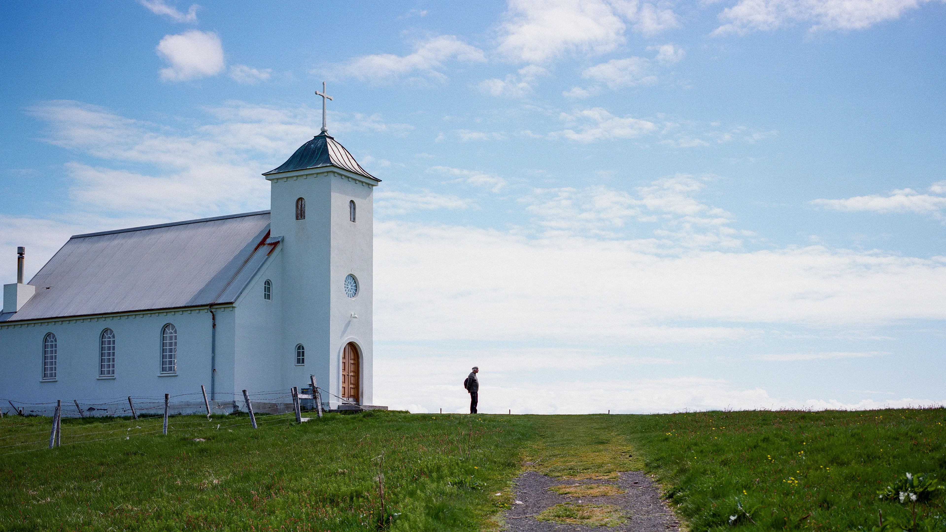 Approaching the church on Flatey, I paused as I noticed a man exiting the church. His kids had wandered off down the distant hillside towards the water. As he stood alone outside the church, I quickly lined up my composition and snagged the shot.