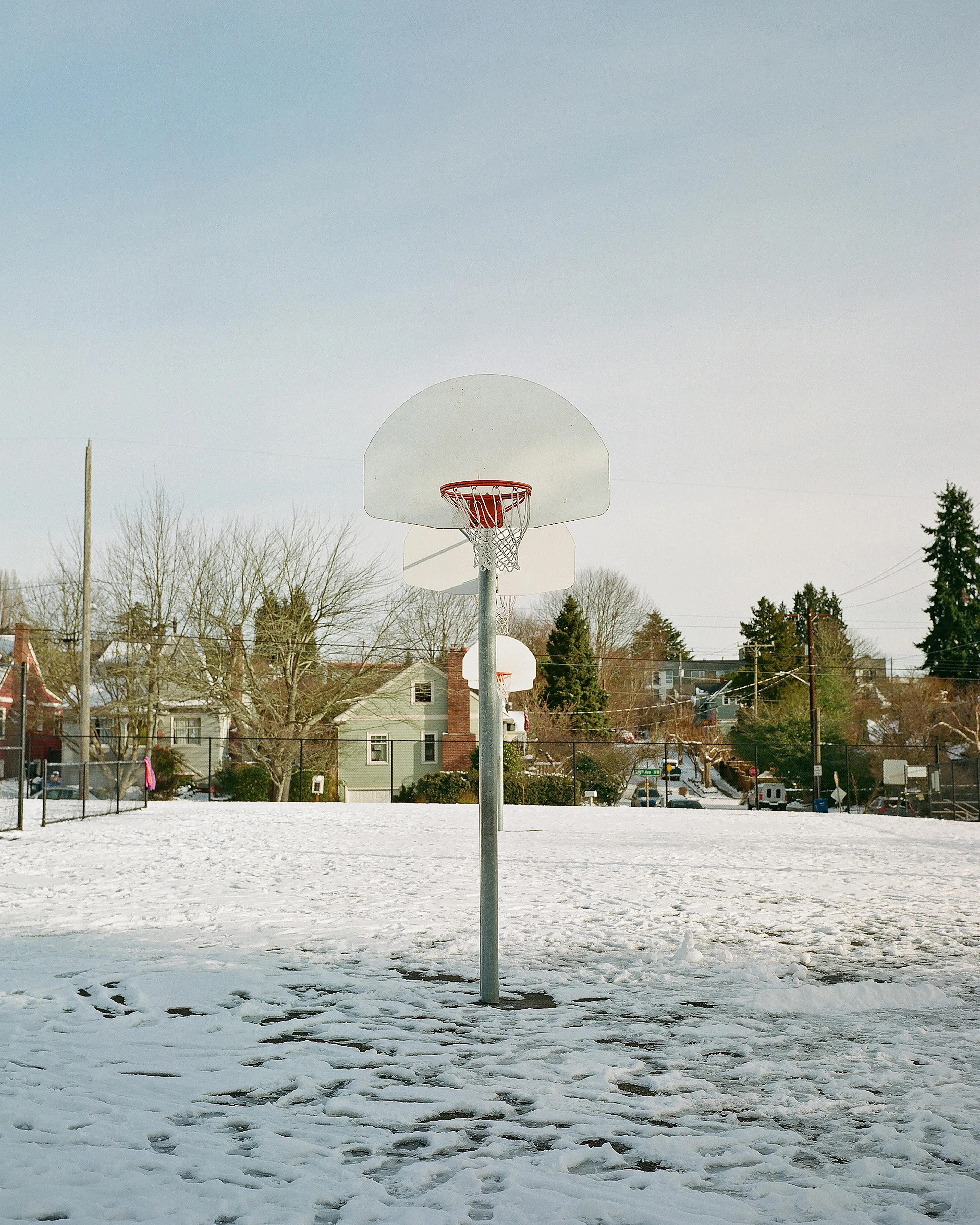 One of the aspects I love the most about snow days is the quiet. When I came across this scene of an empty, snow-covered basketball court at a local school, I couldn't pass up shooting some photos. This place, typically so vibrant with activity, completely silent, blanketed in snow. It couldn't have been more opposite to my memories of loud, crazy days spent on the playground as a kid. 