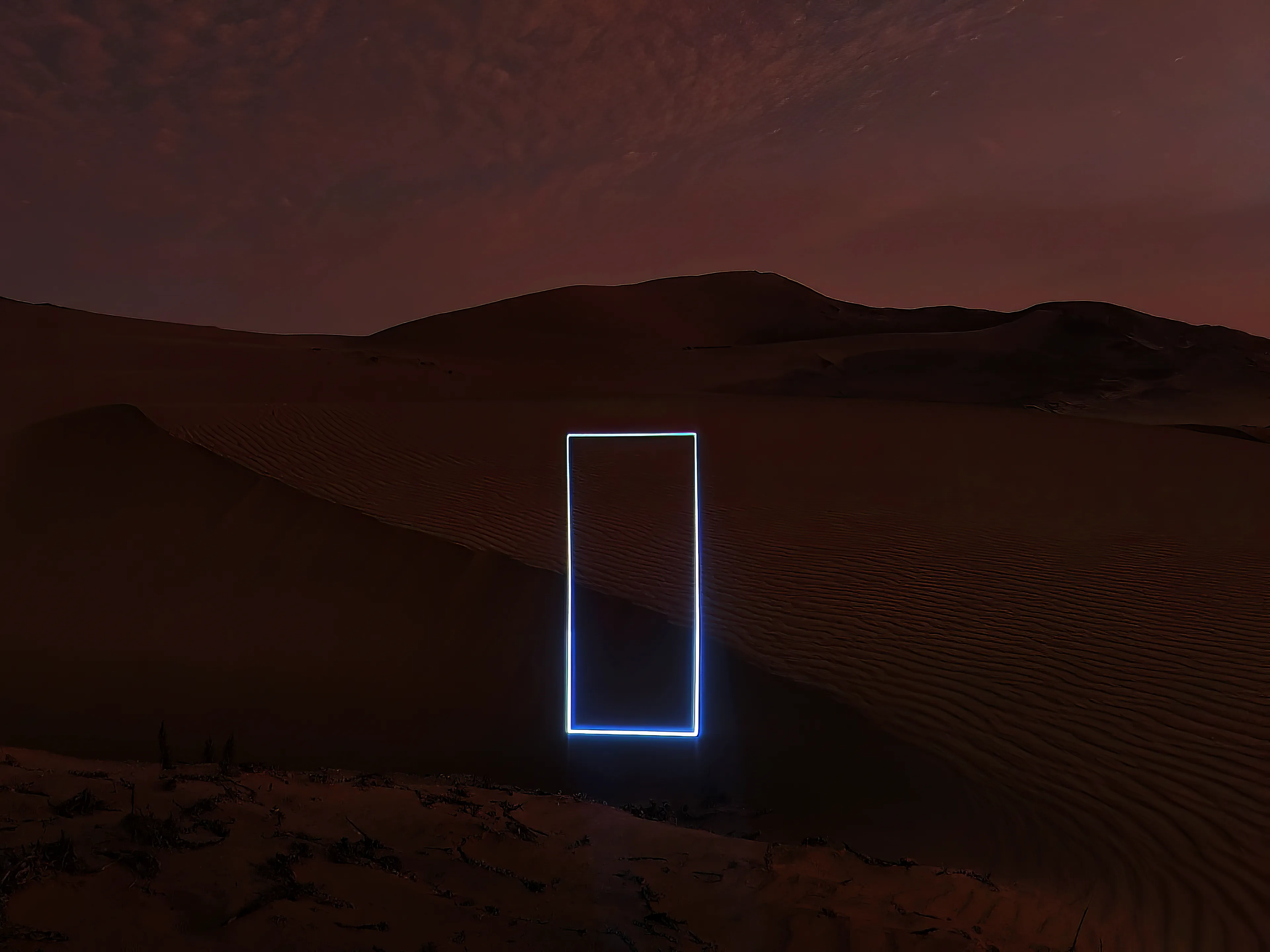 Projection in the Peruvian desert.
After a few days of scouting, I found a hidden patch of sand dunes between mountains, 2 hours North of Lima. After a few hours hiking across the dunes, I used a small laser to make anamorphic projections of coherent light on the sand.

While confronting plain geometric shapes with the curvy dunes of sand grains that formed Millions of years ago, 4 lines of laser light form a tall rectangle across the landscape, a portal to futuristic imaginaries, echoing Kubrick's classic 2001 scene.
