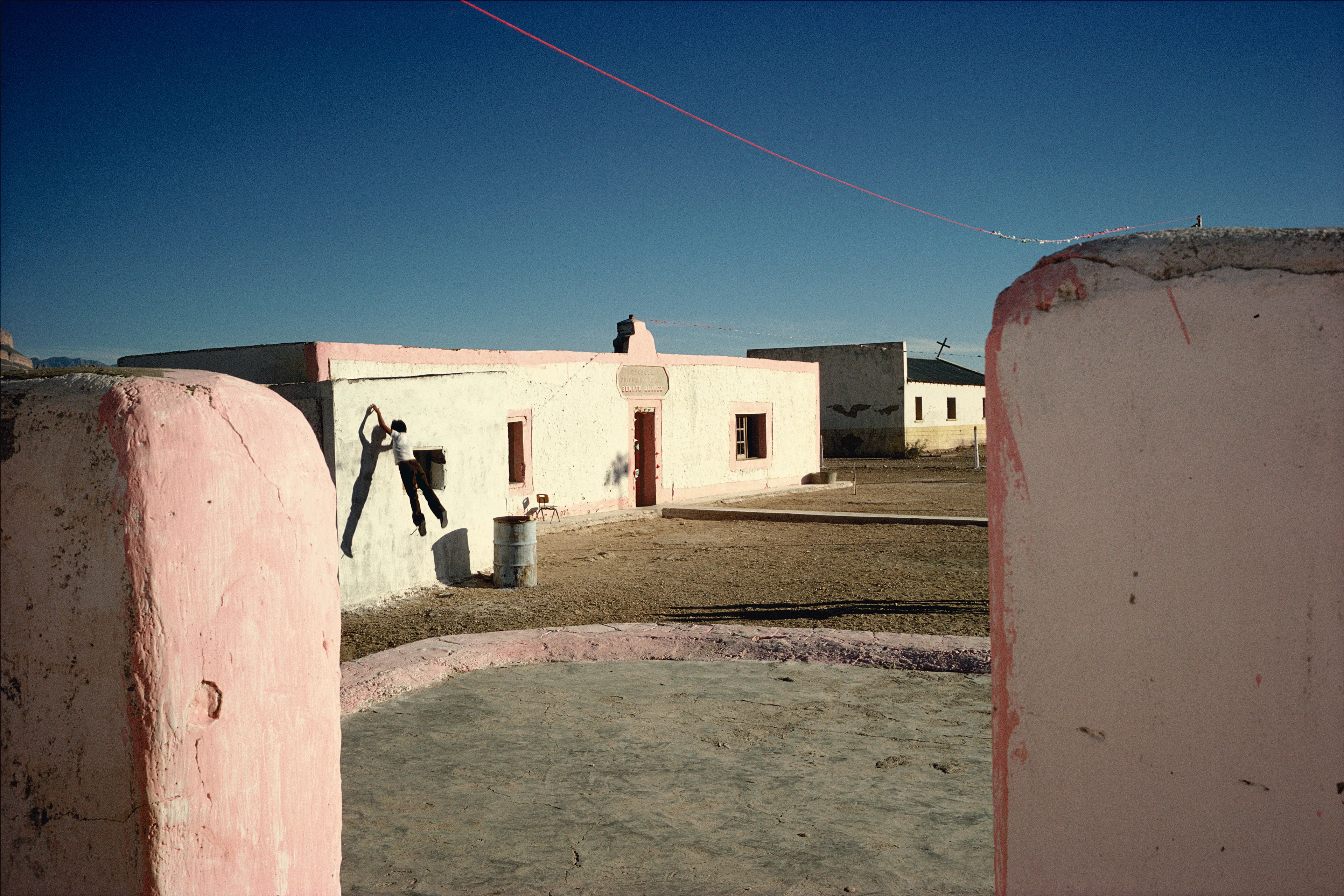 From his first visit in 1975, he was immediately captivated by the vibrant life in the streets of Mexico. While his early black and white photos often feature stark, striking graphics, his foray into color photography starting in 1978—inspired by the light and color of the Mexican streets—marks a turning point in his work.

Throughout his work from Mexico, his rich compositions create compelling visual complexity—‘La Calle’ features strong, saturated colors, which evoke haunting, enigmatic scenes of the everyday. “I work extremely intuitively. I wander, I respond,” he says. “Am I aware of certain elements rationally at times? Sure. But I think that often when I am more aware of them, it usually means that the picture falls flat.”

Webb somehow manages to capture these surprising scenes, which add an otherworldly poetry to the genre of street photography.