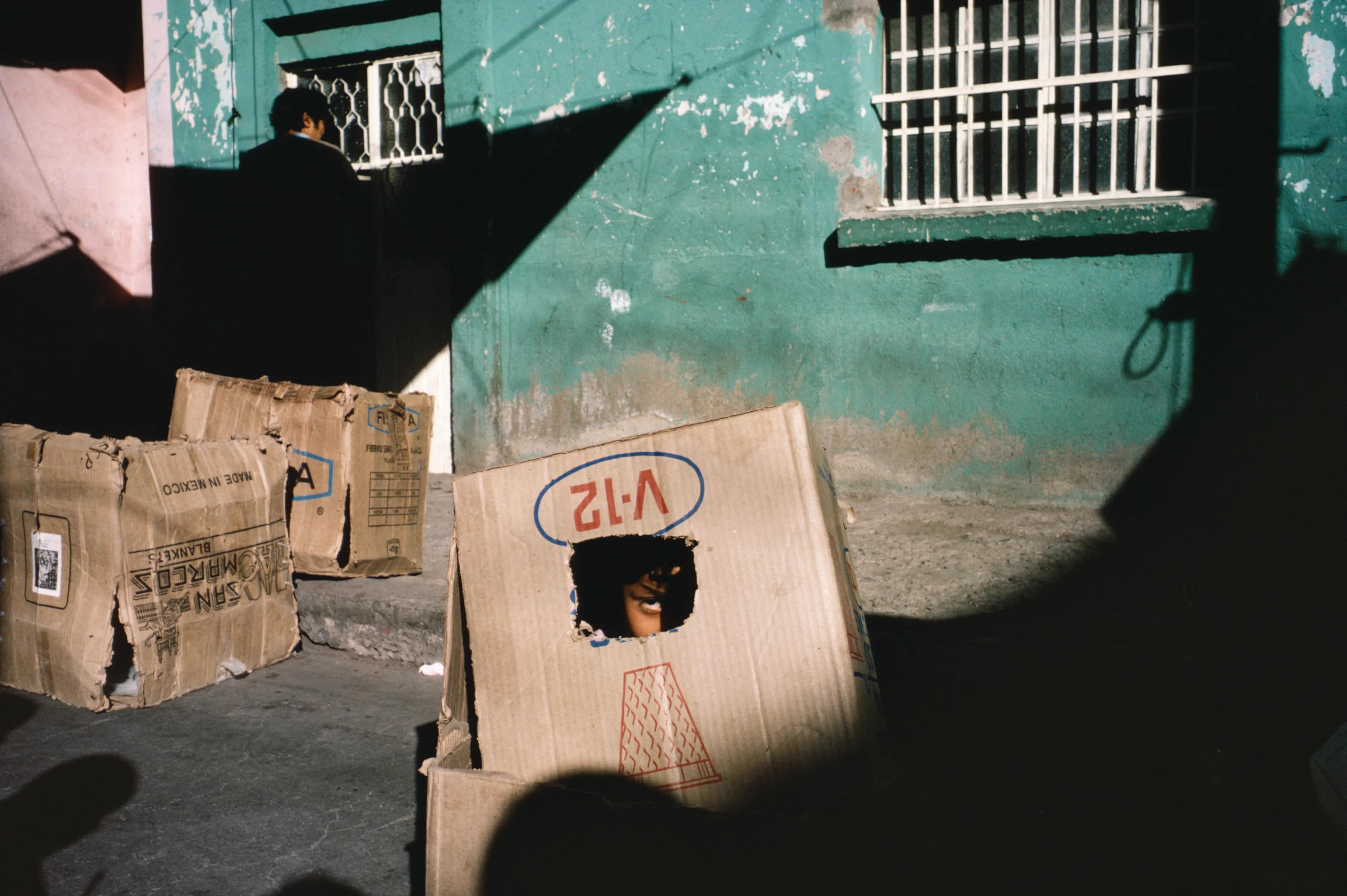From his first visit in 1975, he was immediately captivated by the vibrant life in the streets of Mexico. While his early black and white photos often feature stark, striking graphics, his foray into color photography starting in 1978—inspired by the light and color of the Mexican streets—marks a turning point in his work.

Throughout his work from Mexico, his rich compositions create compelling visual complexity—‘La Calle’ features strong, saturated colors, which evoke haunting, enigmatic scenes of the everyday. “I work extremely intuitively. I wander, I respond,” he says. “Am I aware of certain elements rationally at times? Sure. But I think that often when I am more aware of them, it usually means that the picture falls flat.”

Webb somehow manages to capture these surprising scenes, which add an otherworldly poetry to the genre of street photography.