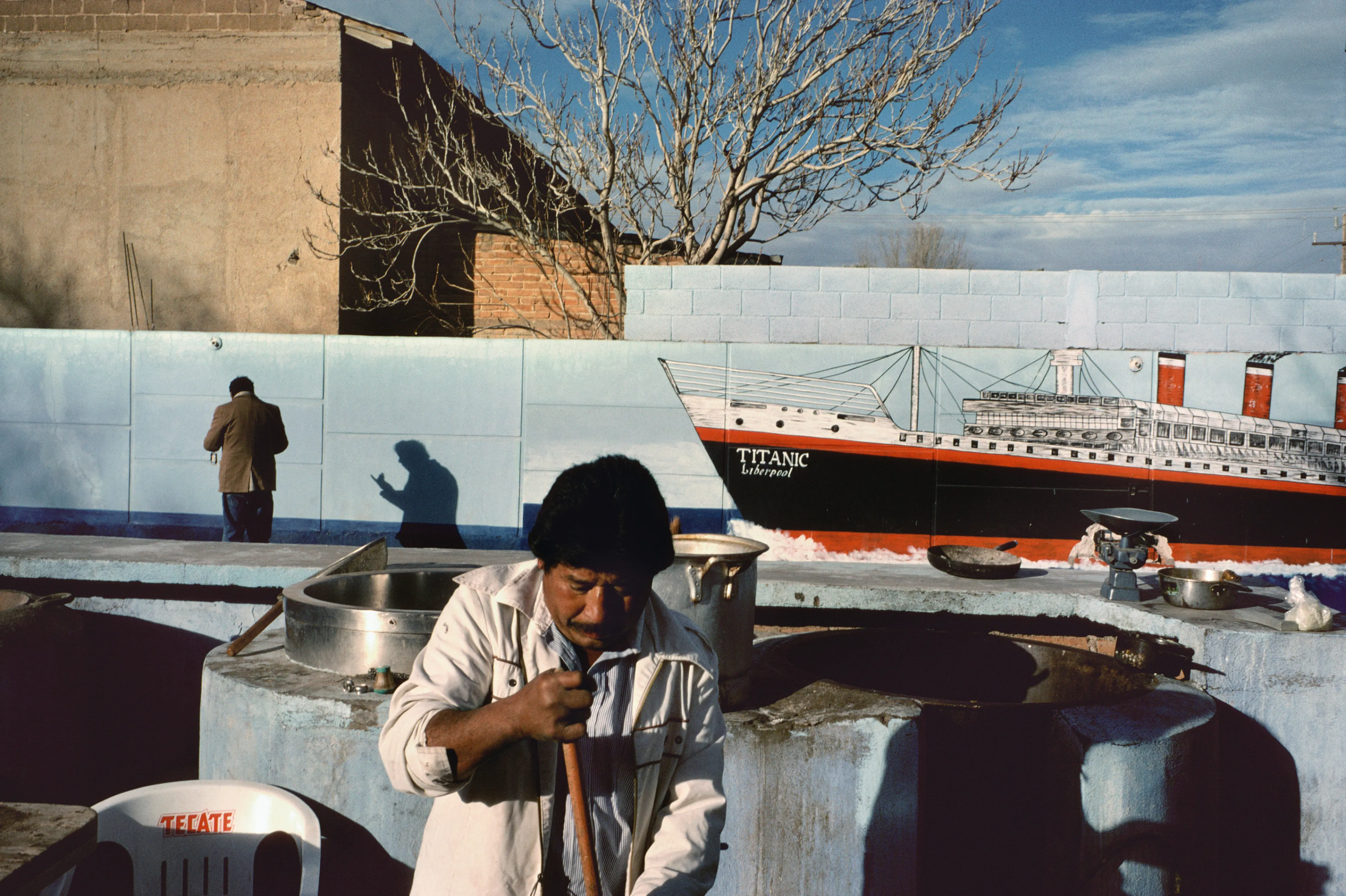 From his first visit in 1975, he was immediately captivated by the vibrant life in the streets of Mexico. While his early black and white photos often feature stark, striking graphics, his foray into color photography starting in 1978—inspired by the light and color of the Mexican streets—marks a turning point in his work.

Throughout his work from Mexico, his rich compositions create compelling visual complexity—‘La Calle’ features strong, saturated colors, which evoke haunting, enigmatic scenes of the everyday. “I work extremely intuitively. I wander, I respond,” he says. “Am I aware of certain elements rationally at times? Sure. But I think that often when I am more aware of them, it usually means that the picture falls flat.”

Webb somehow manages to capture these surprising scenes, which add an otherworldly poetry to the genre of street photography.