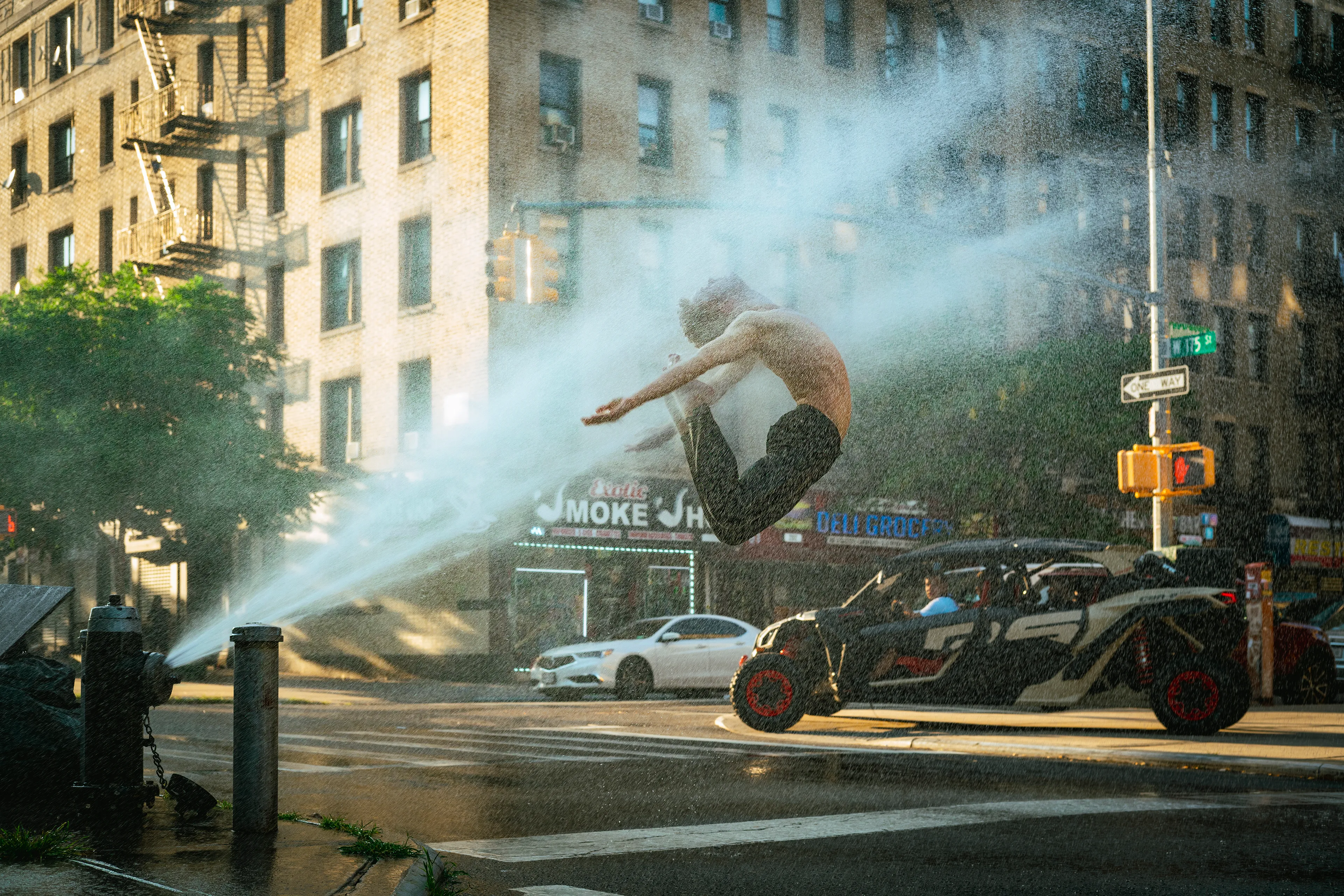 Photographed on July 10, 2022  
Washington Heights, NYC

The magic of NYC summers has always intrigued me. I've always dreamed of creating an image that would portray it perfectly. Nothing says summer in the city like kids playing around fire hydrants while the community gathers around them to beat the heat. I had to travel home to Puerto Rico to be with my family during a difficult time in our lives this summer, so my summer in the city was cut short. I didn’t want to leave the city without creating one last image that would burn in my memory the love I have for it.