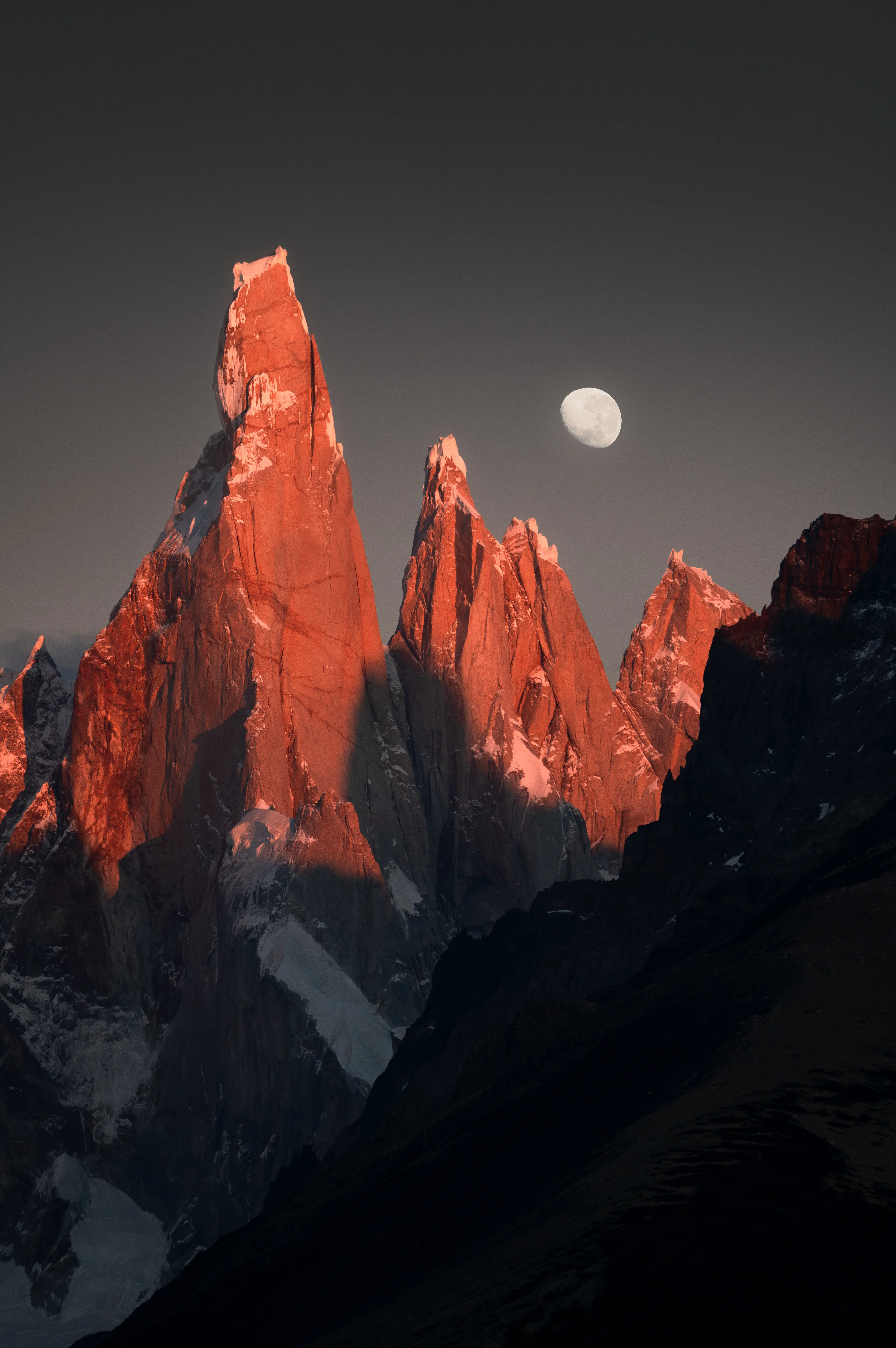 The In-Between speaks to that delicate space between what was and what’s becoming. The crimson alpenglow, the incomplete moon, the silence before sunrise; all reminders of nature’s impermanence. Nothing holds, nothing stays. We are always shifting. This image captures a threshold: not quite day, not quite night, not quite whole, and yet, entirely alive in its transience.