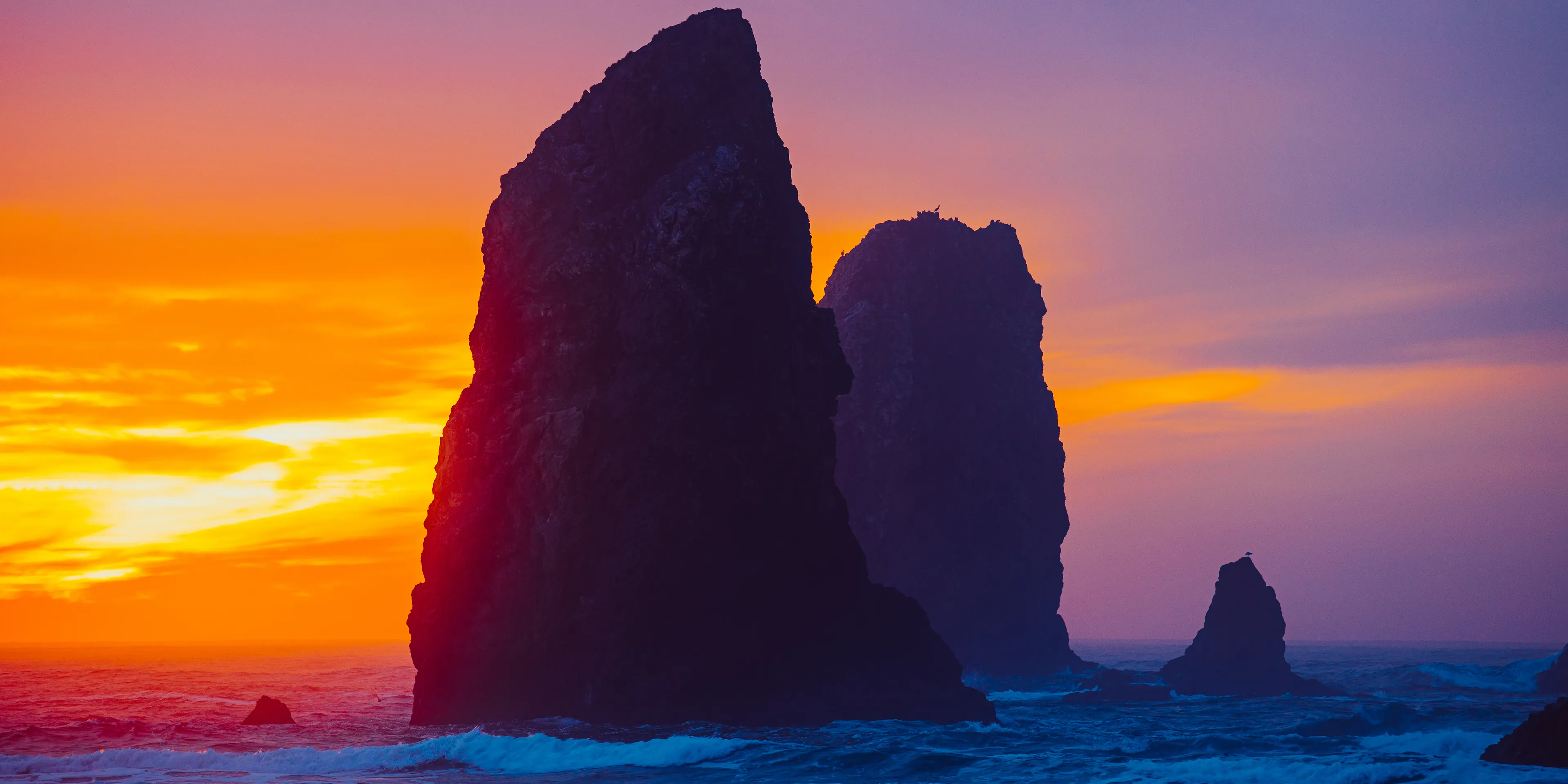 "The Needles" was shot during a visit to one of my favorite places on Earth. I've never experienced sunsets anywhere else like I have in Cannon Beach, and this one won't soon be forgotten. 

**Date:** November 21st, 2020 
**Camera:** Canon EOS R
**Lens:** RF 70-200mm f2.8
**ISO:** 100
**Zoom:** 182mm
**Aperture:** f 4.5
**Shutter Speed:** 1/25