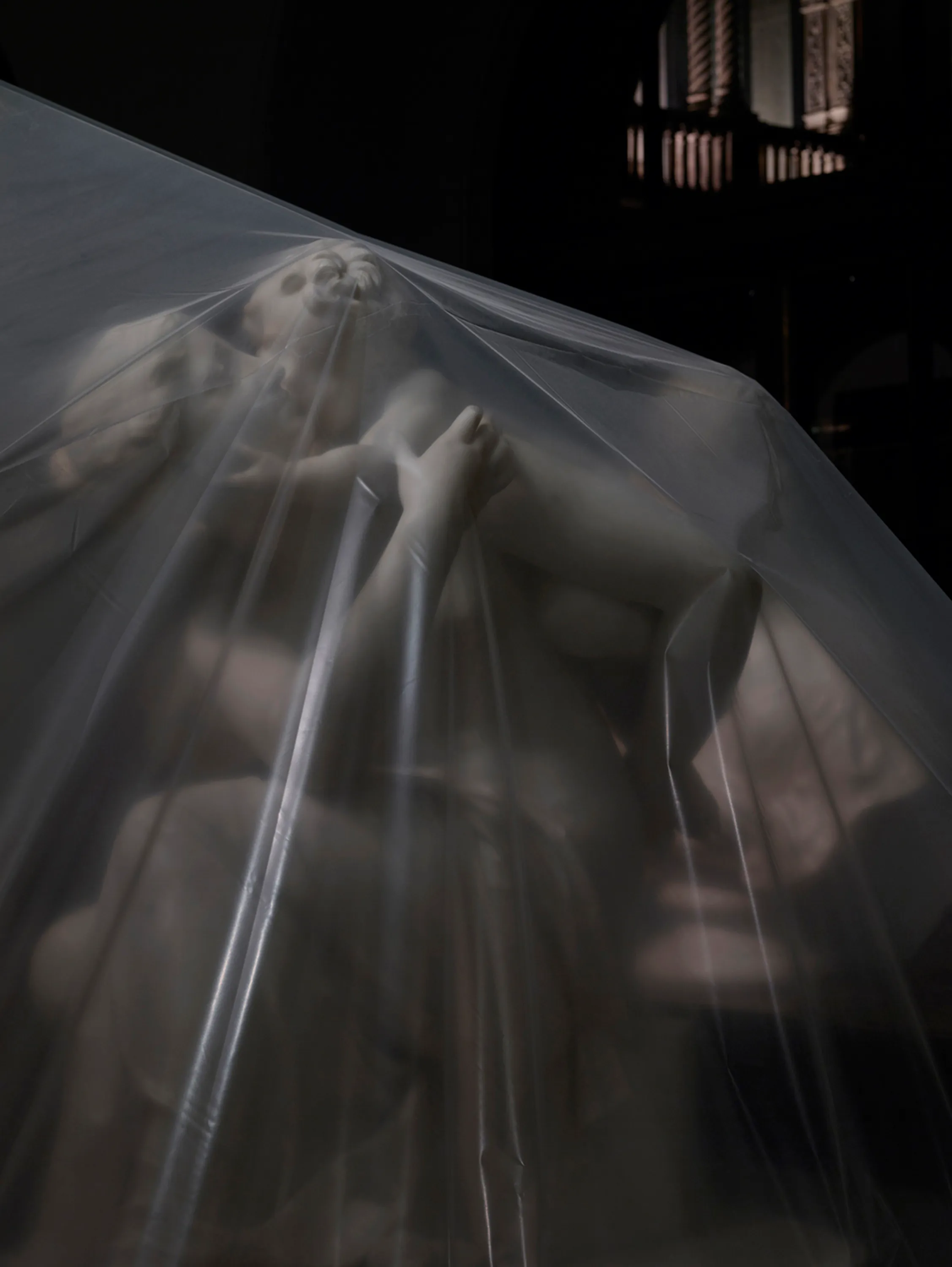 Assembly presents “Shrouded Sculptures” by UK based visual artist Simon Roberts. This NFT collection is a selection of photographs taken during the second Covid-19 lockdown whilst London’s Victoria and Albert Museum was closed to the public. These veiled statues, located in the Museum’s Dorothy and Michael Hintze Galleries, were covered for their protection during refurbishment and Roberts envisions them as a metaphor for our wider experience of the Covid-19 pandemic. The images speak of the extraordinary events of the past year, a global population suspended in time, restricted of movement and freedoms. We were forced to separate from one another, or if we were to meet, we were to hug through thick plastic sheeting, or wave through windows. The beauty of our world felt elusive, hidden beneath an entanglement of political mixed messages and misleading rhetoric. Unlike the statues of merchants, statesmen and traders, many of the sculptures in this gallery represent mythological or allegorical subjects. We see ancient mythology and 18th century neo-classicism meet 21st century plastic and gaffa tape, and the juxtaposition is eerie, disorientating and beautiful.

Simon Roberts is a visual artist based in the UK. Widely recognised for his large-format, tableaux photographs of the British landscape, his practice also encompasses video, text and installation work, which together, interrogate notions of identity and belonging, and the complex relationship between history, place and culture. His work has been exhibited nationally and internationally, and resides in major public and private collections, including the George Eastman House, Deutsche Börse Art Collection and Victoria & Albert Museum.