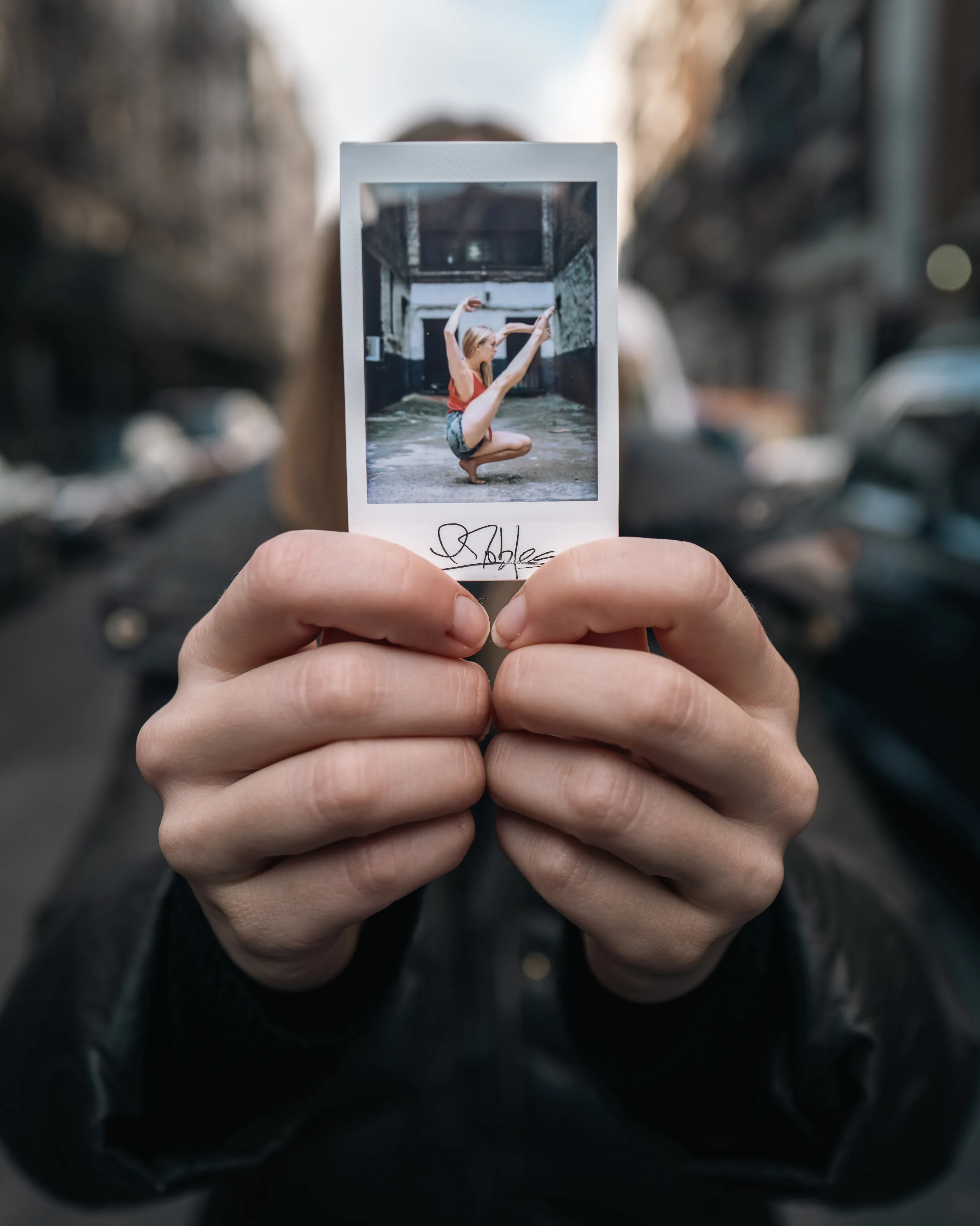 In 2013, I started a photography series that sought to inspire viewers to look at their urban surroundings in a new light. By featuring dancers in these settings, I aimed to challenge the way we perceive the spaces we encounter every day. Over the past nine years, this project has grown into a significant body of work that has shaped my career and opened up new opportunities for me. As a special gesture, I would often present the dancers with an instant photograph of our session together. Seeing their joy and pride in these mementos inspired me to start photographing them holding their instant prints. 'Dance Mementos' is a tribute to this ongoing series, showcasing a selection of my favorite images portraying the dancers with their photographs.