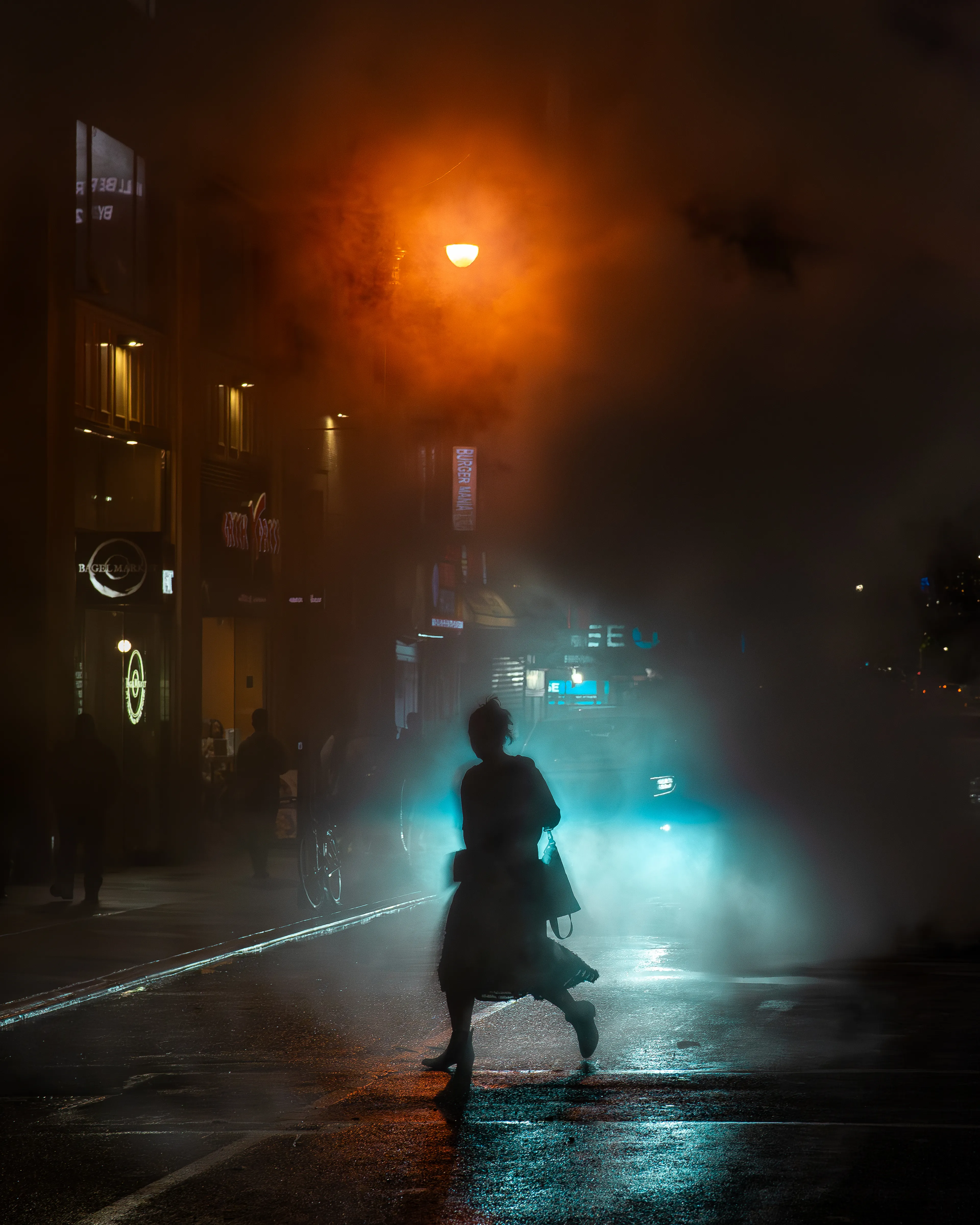 NIGHTMOVES is a 1/1/10, candid street photography collection from Dave Krugman that spans a decade of exploration of light in the neonoir setting of New York City by night. This collection is focused on the spectrum of artificial light against a natural dark, isolation in the density of the city, and the interplay of character and setting as found in these unstaged scenes. In these shadows, we can see ourselves, separated only by our luminous outlines. 

As soon as the sun sets in New York City, the world of night emerges. Darkness envelops the streets, and, one by one, the lights flicker on to push against the shadows. Shades move like ghosts through this continuum- shifting, blocking, bending light- like spirits projected from some distant realm who fade away as fast as you first saw them.  Every scene a stage for our shared story- motion at midnight, frozen in time, held still for just this instant- from dusk ‘til dawn is NIGHTMOVES