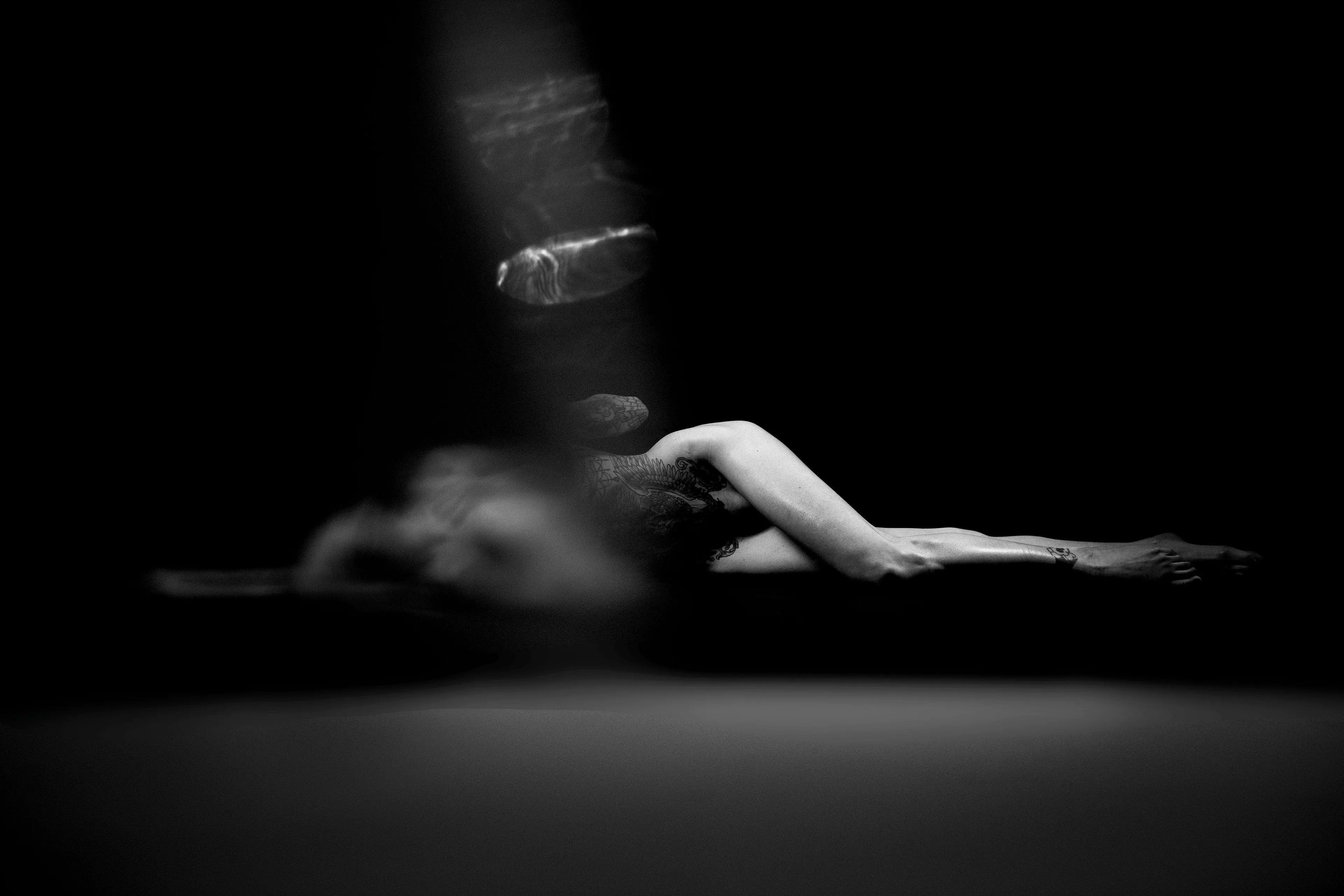 Figure Studies is a series of nude portraits that subverts the viewer’s expectations of the female form. Shot through glass, the images are distorted, even ghost-like. Though strange and unsettling, the forms remain familiar and beautiful. Light finds the bodies in the dark while holding the viewer at arm’s length, as if seen through a veil. 

Part of Caitlin Cronenberg’s Figure Studies collection. 
