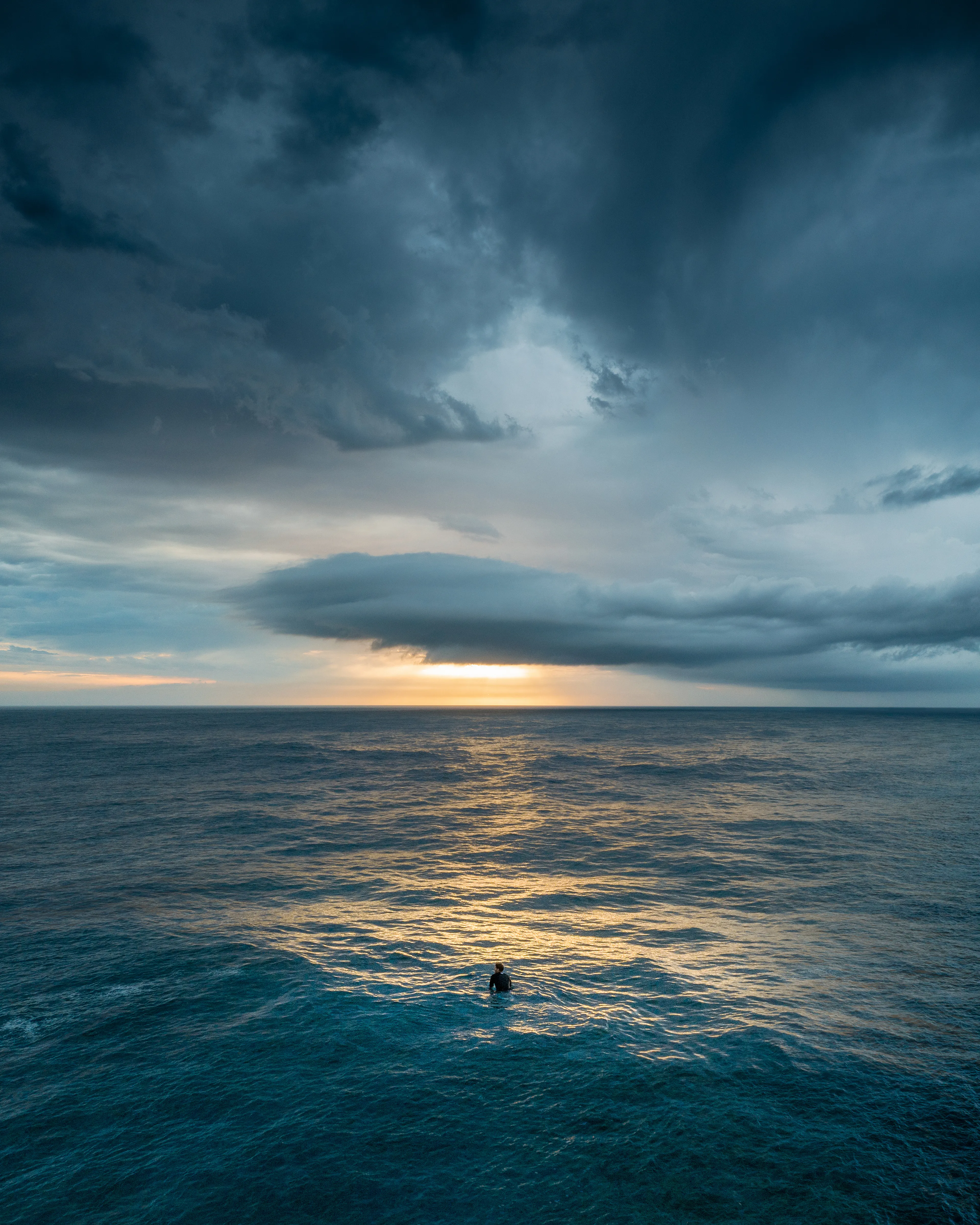 Being out in the surf alone is one of my favourite things to do. Capturing this lone surfer taking in the sunrise as a shelf cloud rolled through, I could feel the longing to be out there growing and overtaking my soul. 

Usually I would finish up getting my compositions and capturing the best of the light, then pack up the gear and paddle out for some waves. But this was a special day. I had just met a fellow photographer that is a massive supporter of the community in the NFT space for our sunrise shoot. Getting to know him was a great experience and a friendship was forged. 

Sometimes being lost at sea can be a good thing and being alone never lasts long when you share a deep passion for the ocean and for art. There's always someone down to earth to connect and share moments with. I hope this image connects us one day.

Artist: New Light Visuals  

Title: Lost at Sea  

Edition: 1/1  

License: Extended Editorial