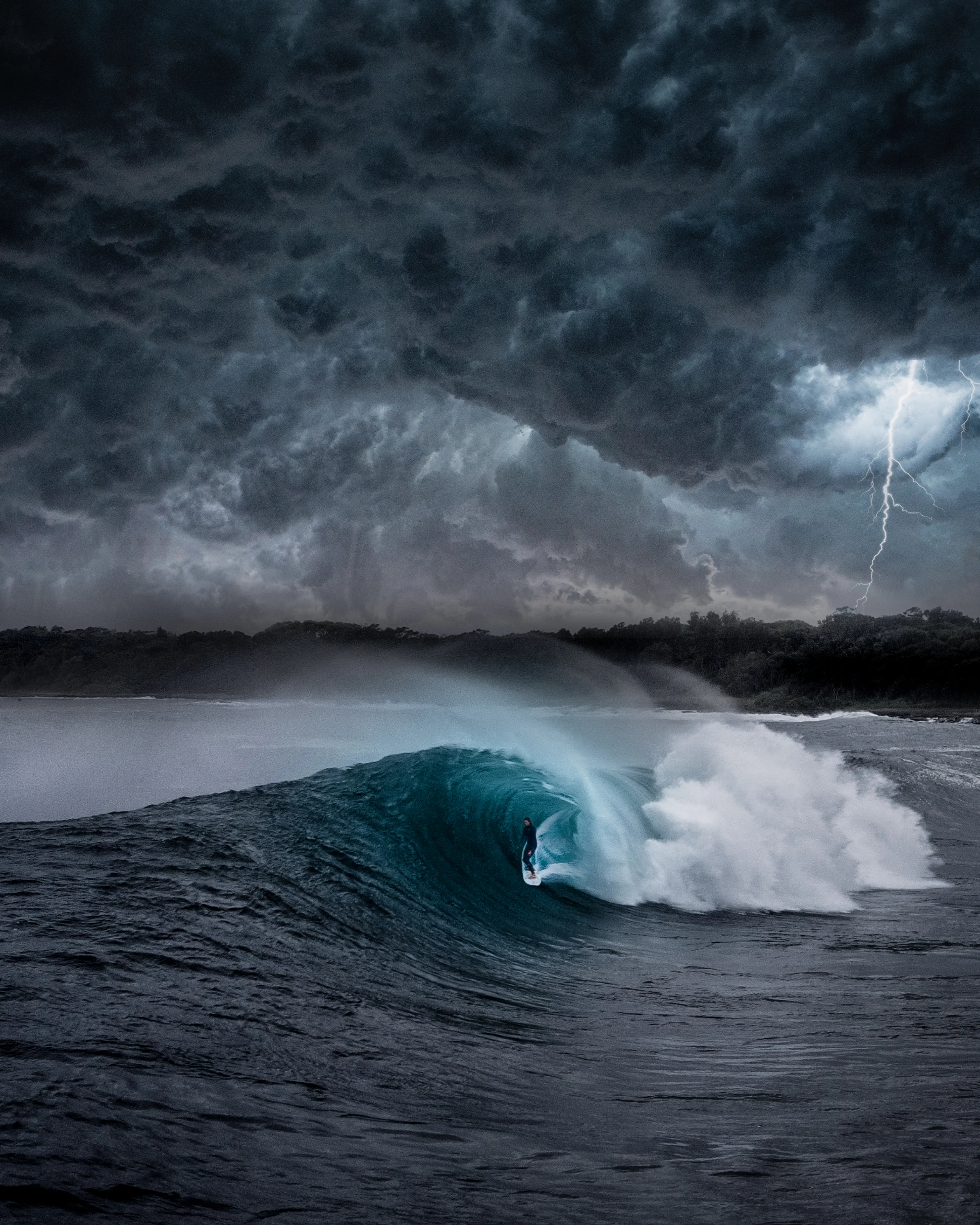 In the belly of the beast, under the whale's mouth. 
This day was a wild one. A turbulent day at a dangerous surf spot where strong swells explode over a shallow slab reef break. I decided to venture out and test myself. However, after two waves, the swell grew rapidly and the reef became visible beneath, prompting me to exercise caution and stay within my limits. 

Upon returning to land, I witnessed a surfer being towed into the larger waves via jetski. As I filmed the scene with my drone, a violent storm approached, the sky putting on a spectacular display. Despite the gale force winds, my drone handled well and I captured some incredible footage. It was an intense moment to be less than 1 meter off the water surface with the drone, avoiding the oncoming waves, whilst a high velocity storm cell blew in from the south. 


There was no way I was going to miss the opportunity to shoot something epic so I braved the conditions and was able to capture some amazing moments. This piece is a composite image that harnesses the feeling of what I experienced this day in, and above the ocean. The surfer captured via drone and the sky captured using my handheld camera, manually stitched to create wave theatre.