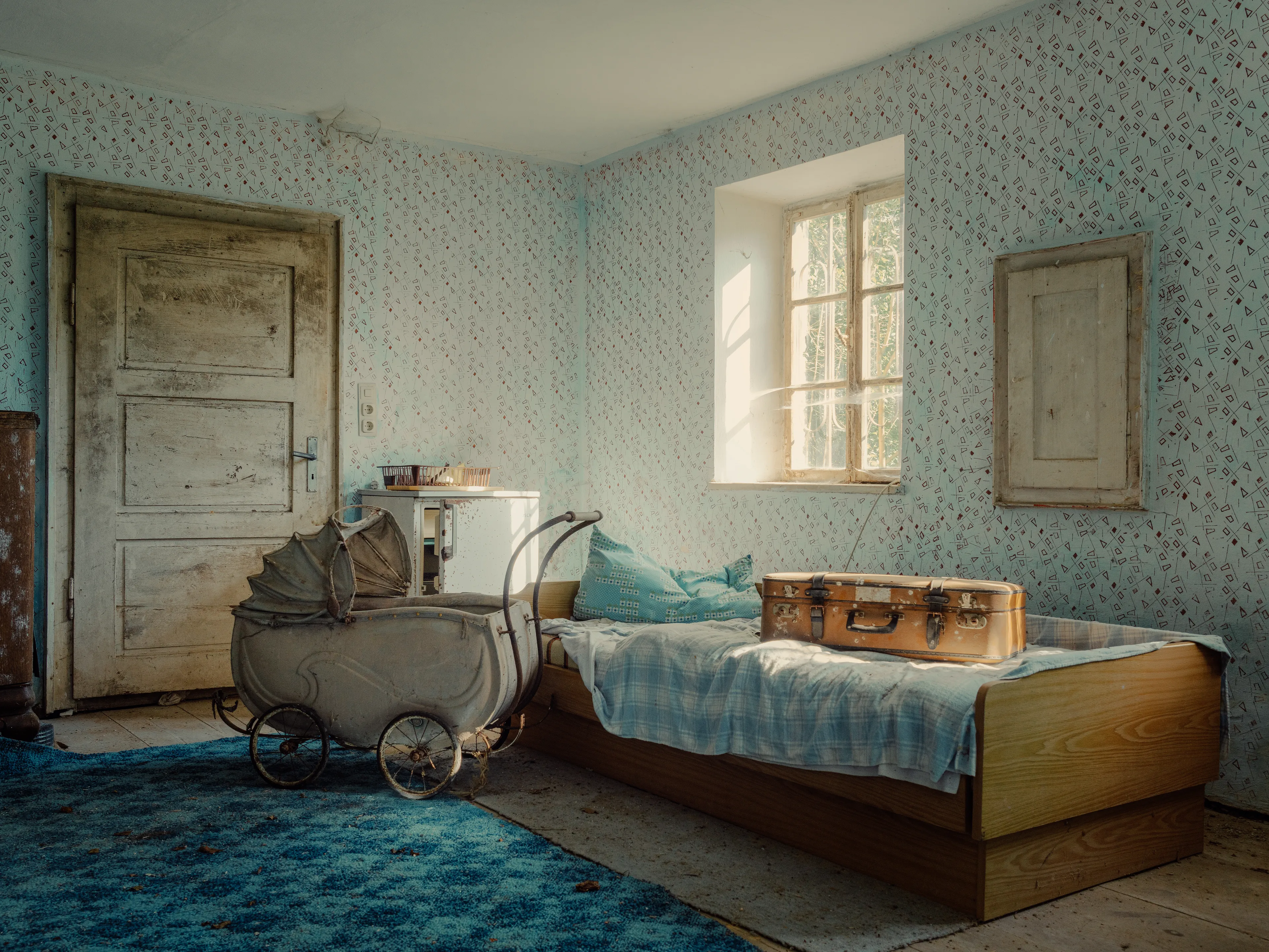 The room feels paused,
as if someone still lives in the quiet between objects.
A suitcase waiting.
A crib without a name.
And sunlight that remembers more than we do.