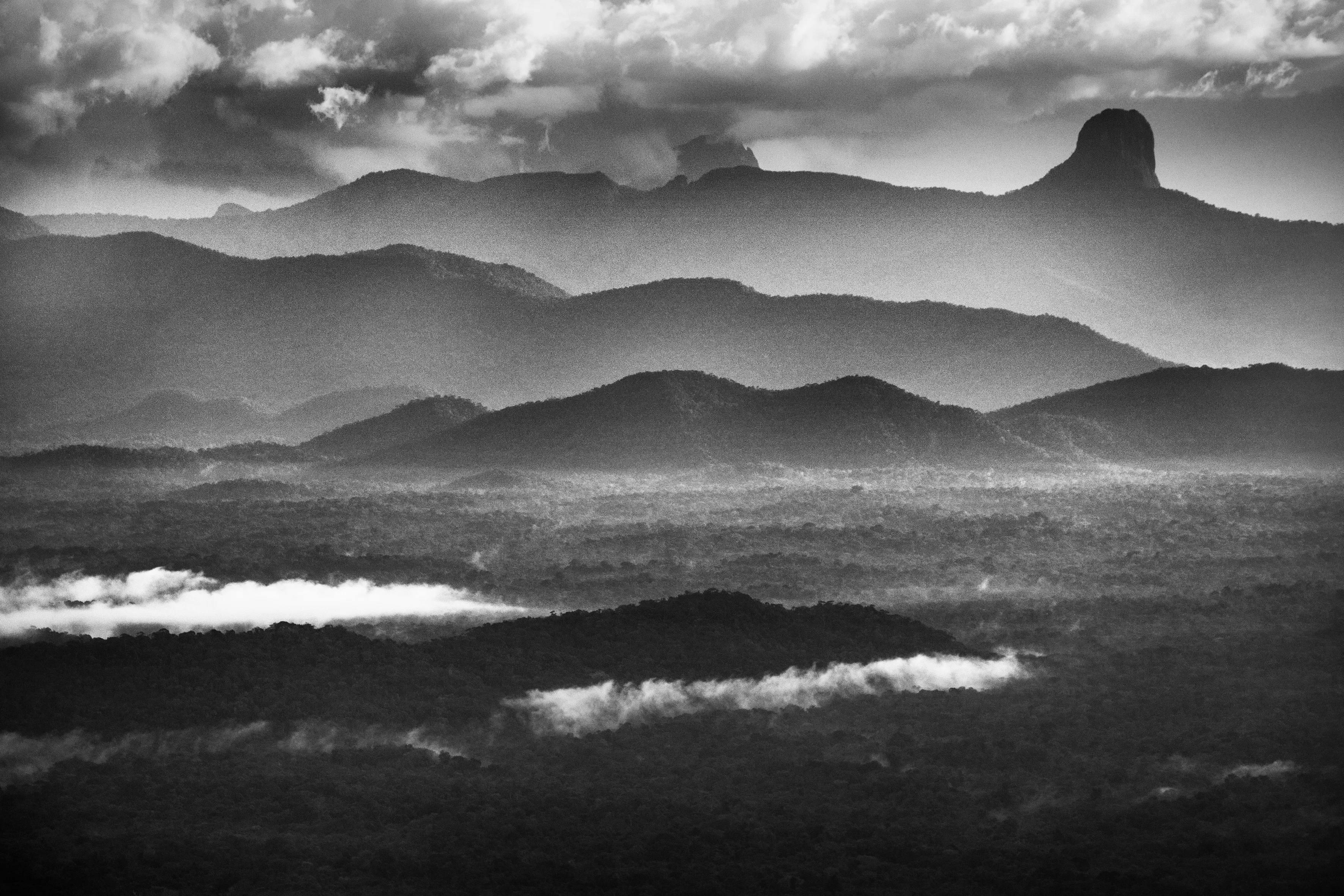 Imeri mountain range, State of Amazonas, Brazil, 2018

The mountain range that defines the life of the Amazon basin lies far to the west of Brazil. But if the Andes provides most of the water that flows through hundreds of tributaries into the Amazon River, Brazil too can boast mountains. To the southeast lie the Brazilian Highlands, which include the mineral rich state of Minas Gerais. Heading north towards the heart of the rainforest, the landscape remains undulating, with a hilltop known as Serra Pelada in the state of Pará drawing one of the country's biggest-ever gold rushes in the 1980s. Even closer to the Amazon River, occasional large rock formations appear like intruders into the quiet order of the lowlands.