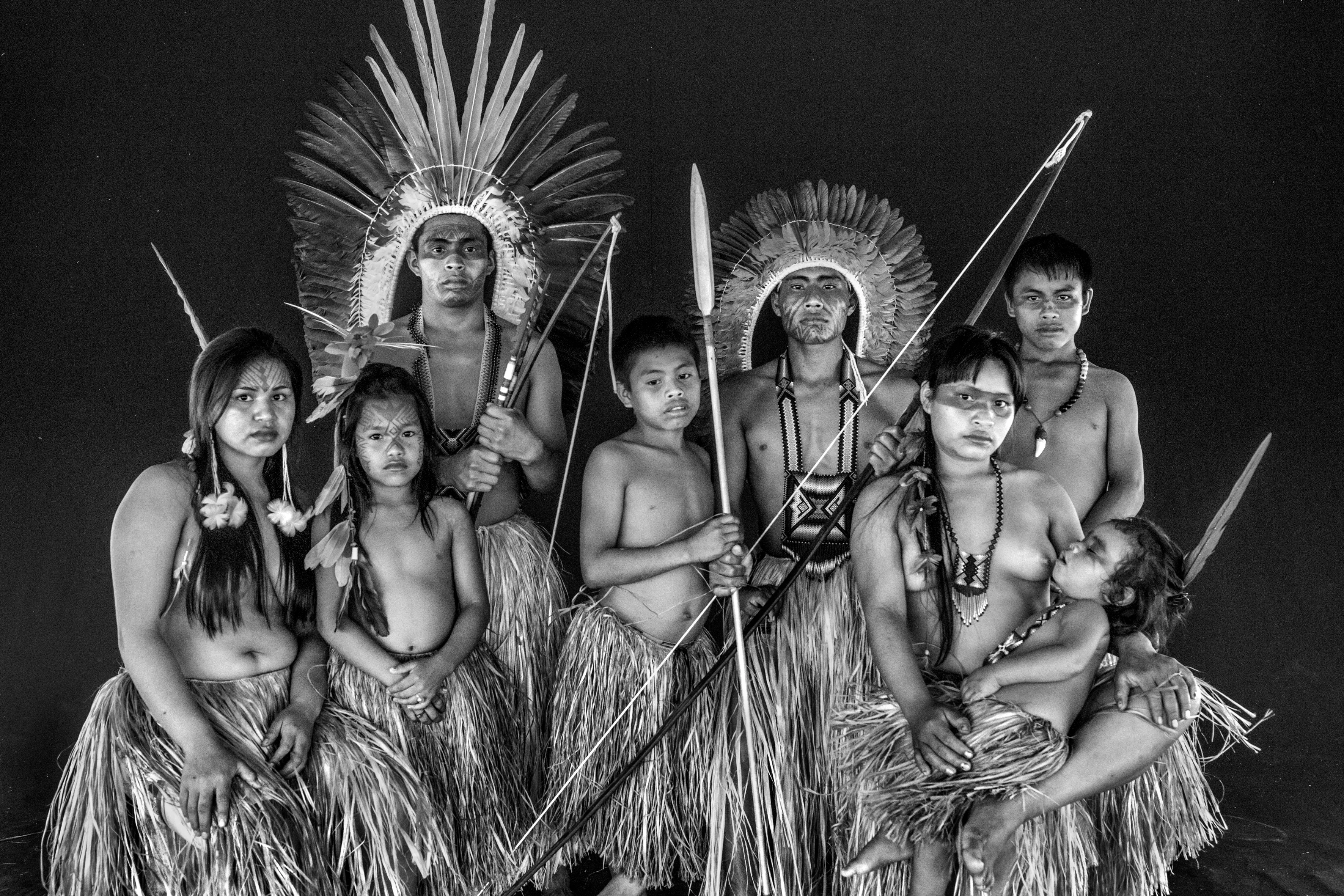 Nova Esperança community, Rio Gregório Yawanawá Indigenous Territory, State of Acre, Brazil, 2016.

In the course of some 50 years, the Yawanawá have emerged from complete invisibility into a period of exuberant cultural activity, becoming a reference point for sustainable living and indigenous culture for travelers from all over the world. In 1970, there were just 120 of them, with rampant alcoholism and the resulting social and cultural breakdown, to the point where their language was about to disappear. They were pressured not to use their language in front of whites, mainly by the owners of the rubber plantations, who controlled the forests of Acre from the late 19th century. The plantation owners treated them as slaves and did not want the language to reveal the existence of native tribes who might claim ownership of the land. Another threat was posed by Evangelical missionaries who had enforced Christian worship and attacked traditional indigenous rites as "demonic." Biraci Brasil Yawanawá, better known as Bira, assumed leadership of the group in the early 1990s, expelled the missionaries, got rid of the bibles, reestablished teaching of the traditional language, and began encouraging study of the old myths and stories as a way to pass down the old people's knowledge and memories to the new generations. In three decades, the population has grown to about 1,200 people.