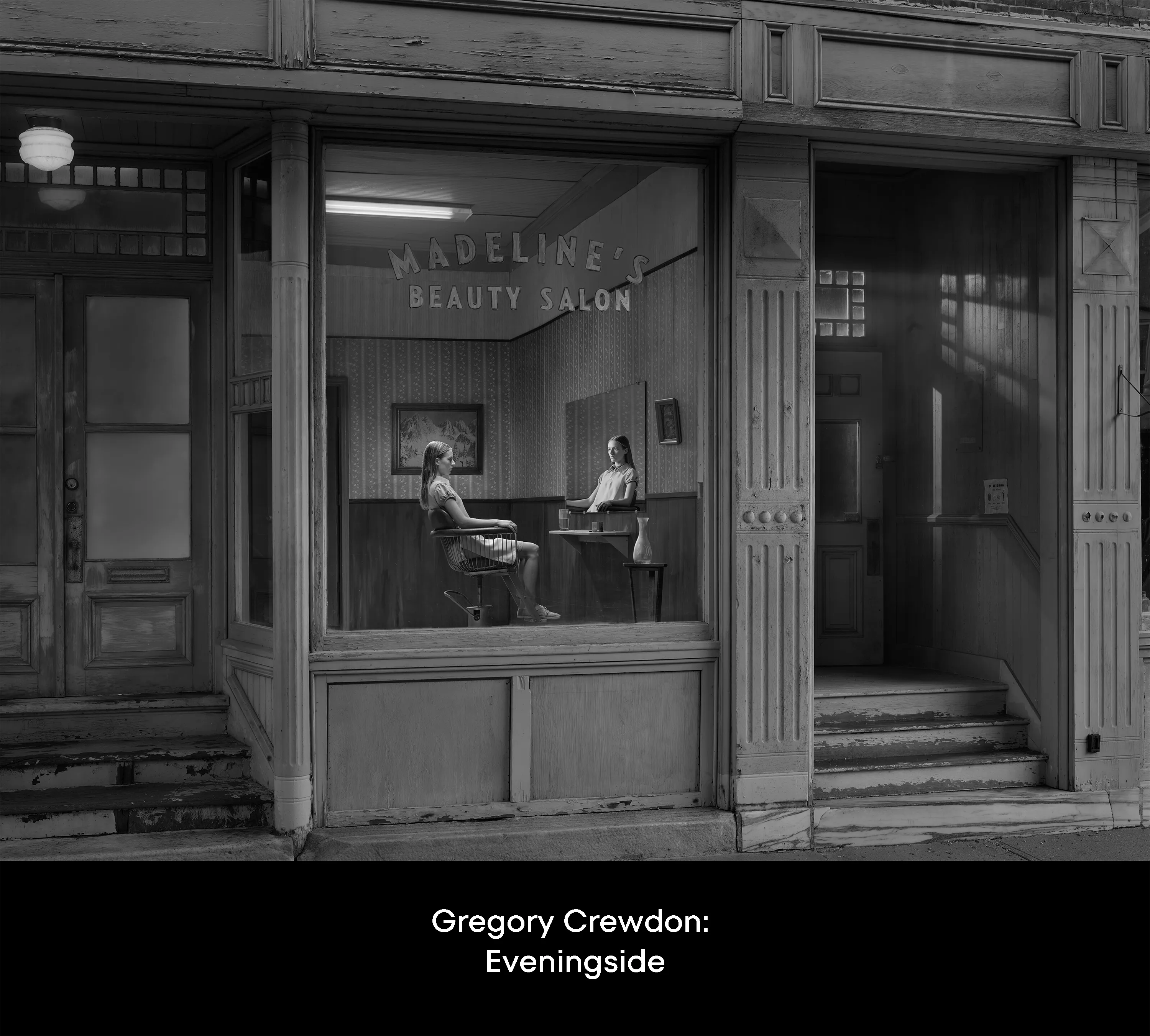 In Eveningside (2021-2022), Crewdson explores moments of contemplation within the confines of quotidien life, in places of employment, and in moments just outside of those work structures. The figures populating the pictures are sparse, and are often seen through storefront windows, in mirror reflections, or positioned underneath the mundane proscenium found in the midst of their everyday routines: railroad bridges, doorways, porches, the overhanging roofline of a bank teller drive-thru, a dairy bar, a corner market, or a hardware store. Bringing his vantage point closer to the figures, using a heightened range of light and darkness, special effects such as fog, rain, smoke, and haze, and for the first time using his now ubiquitous full production and lighting team in a monochromatic palette, the result is a rich gothic atmosphere, evocative of film noir and classic cinema, but with the capabilities and clarity of the most current technology available in digital photography. 

Portfolio of 200 images from Eveningside (2021-2022)