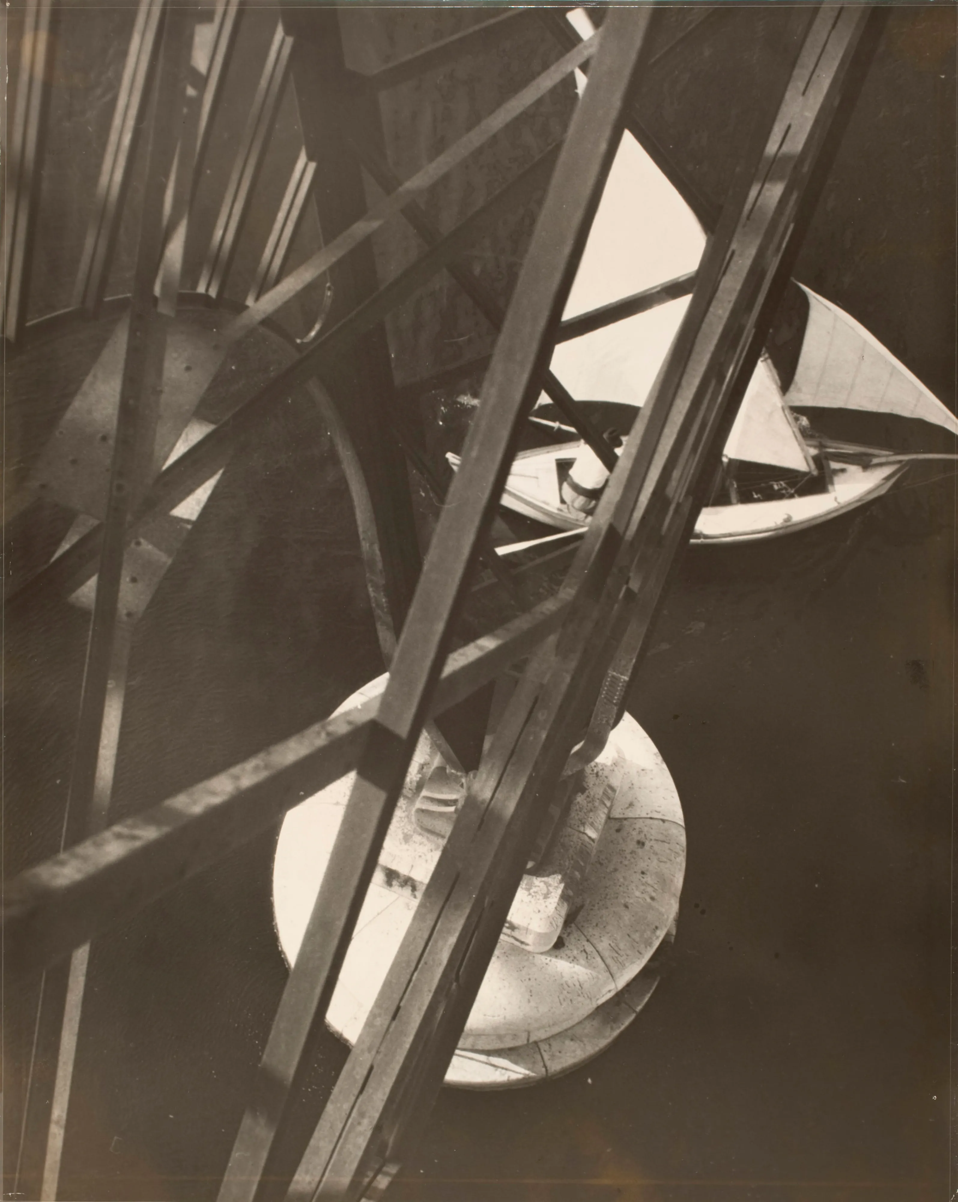 Bauhaus Photography.

This may well be the penultimate example of Modernism as expressed in photography in the 1920s. Moholy-Nagy climbed to the top of the Marseille transporter bridge and photographed straight down. The rhythm of the metal construction, printed dark, contrasts with the circular concrete pillar. Two triangular sails of a ship passing by prevent the photograph from turning into an entirely abstract entity.

The legacy of Hungarian artist Laszlo Moholy-Nagy is among the most cherished in the lineage of photographic art, and he can be defined as a visionary whose radical experiments with photography entirely re-imagined the possibilities for the medium. Working in the early 20th century when photography was not considered a form of high art, Moholy-Nagy actively sought to break down boundaries and find new languages of photographic discourse. In doing so, he left behind an oeuvre of visual ideas that have provided artistic license to a century’s worth of photographers to experiment boldly beyond the conventional definitions of what photography is expected to be.

Edition: 1 of 1