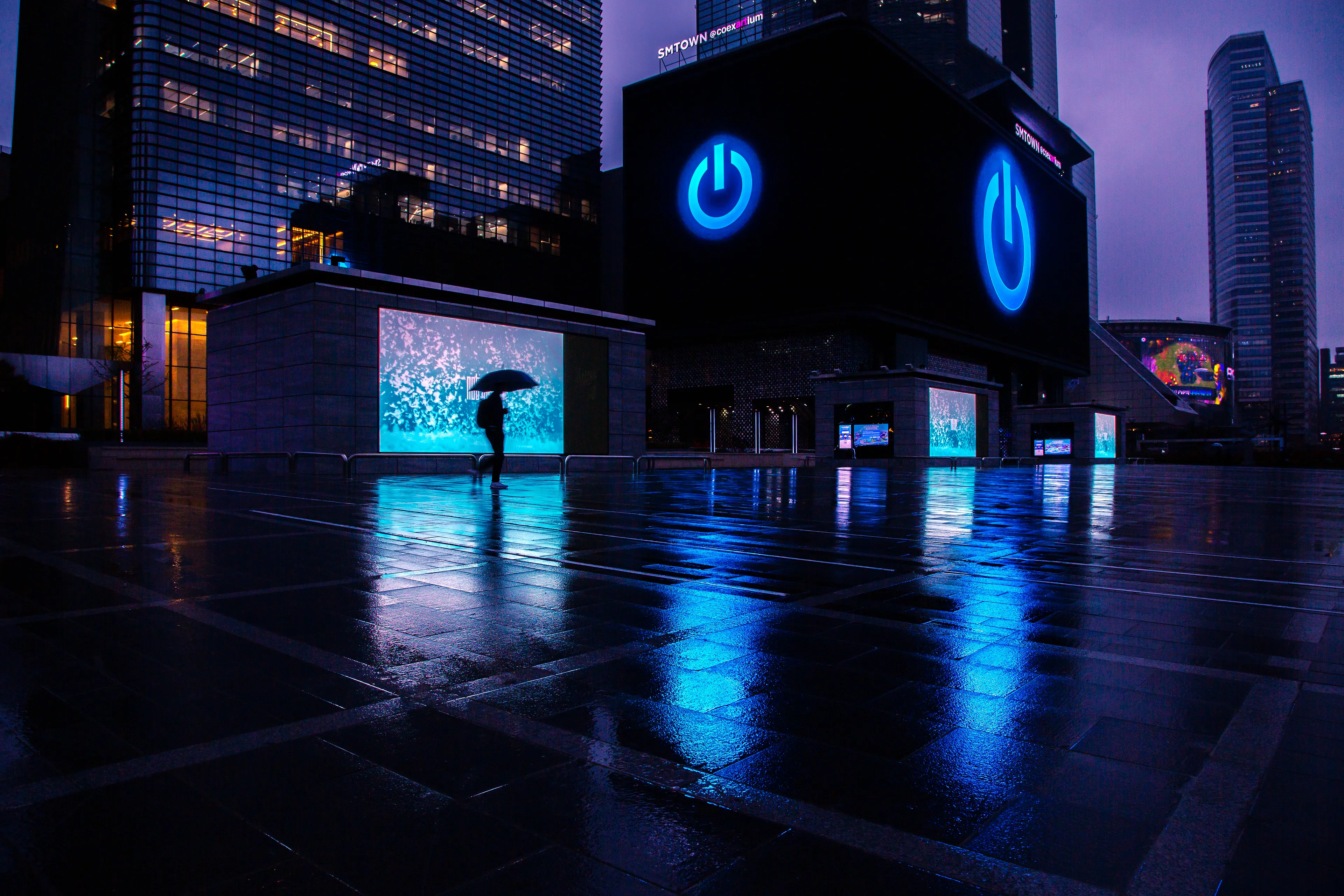 I spent three hours in the rain waiting for the perfect moment to take this picture. This picture also won me the cyberpunk 2077 contest. It is one of the highlights of my photography book that was released today and really wanted to share the story behind it. It was taken in Seoul, South Korea on a rainy evening. Those large LED displays are a permanent exhibit at the COEX mall in Samsung station. The hardest part was getting the right person at the right time with the perfect screen.